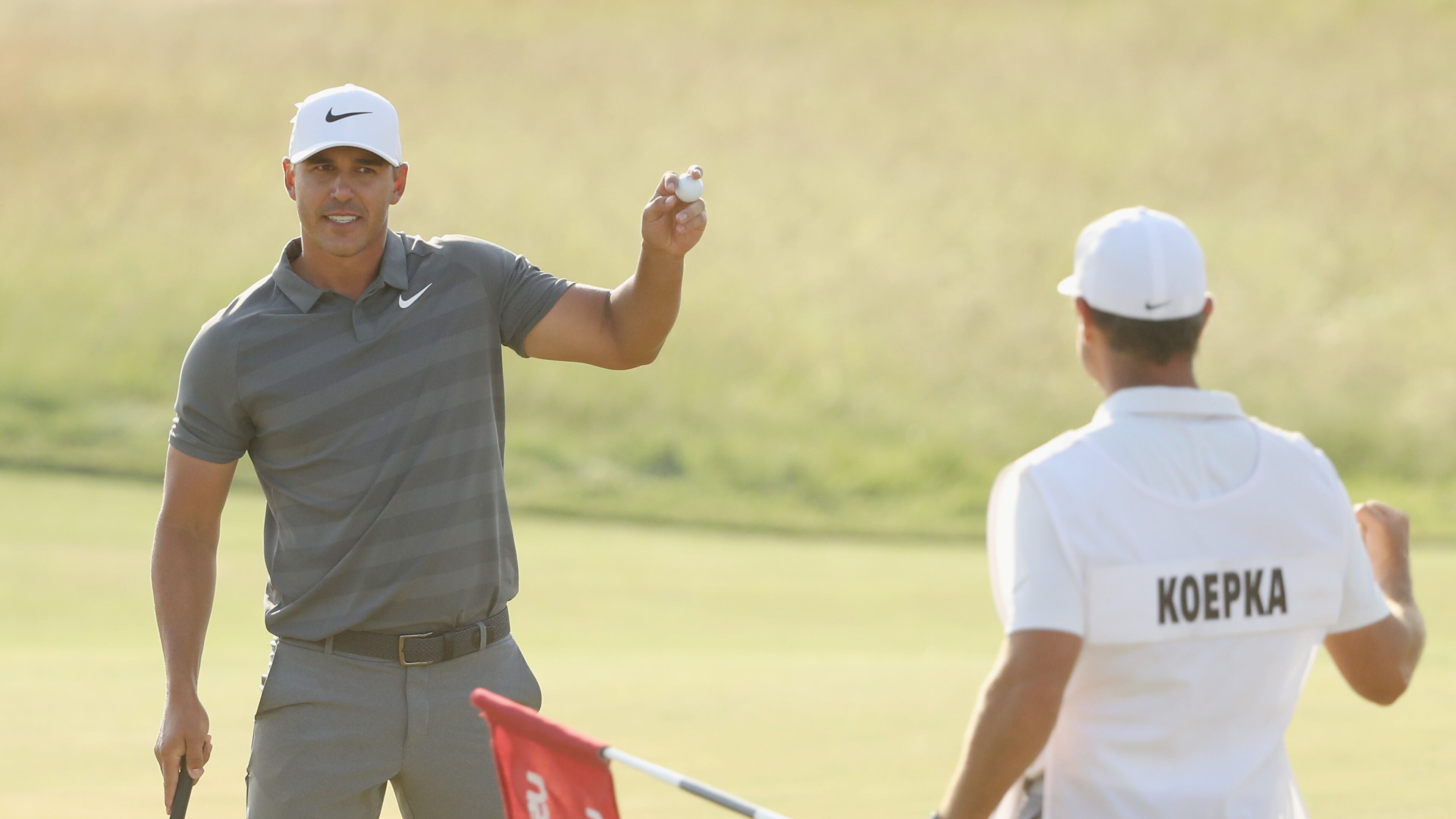 Brooks Koepka begins a muted celebration after putting out on 18 Sunday, with a second U.S. Open title near. (Streeter Lecka/Getty Images)