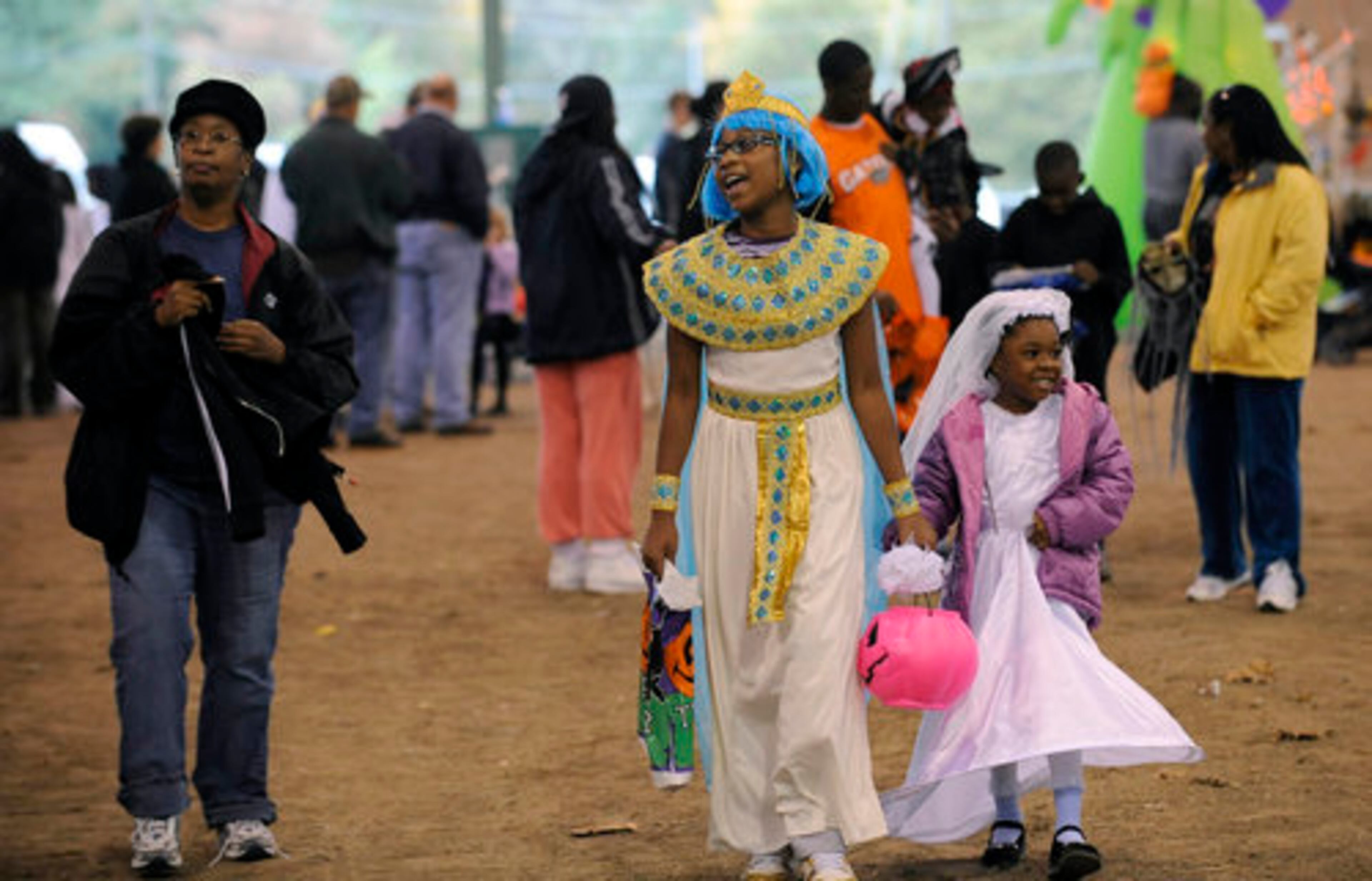 Angela Starr (left), of Mableton, and her nieces Nadea Walters (center), 10, and Ayani Scott, 5, walk to a booth.
