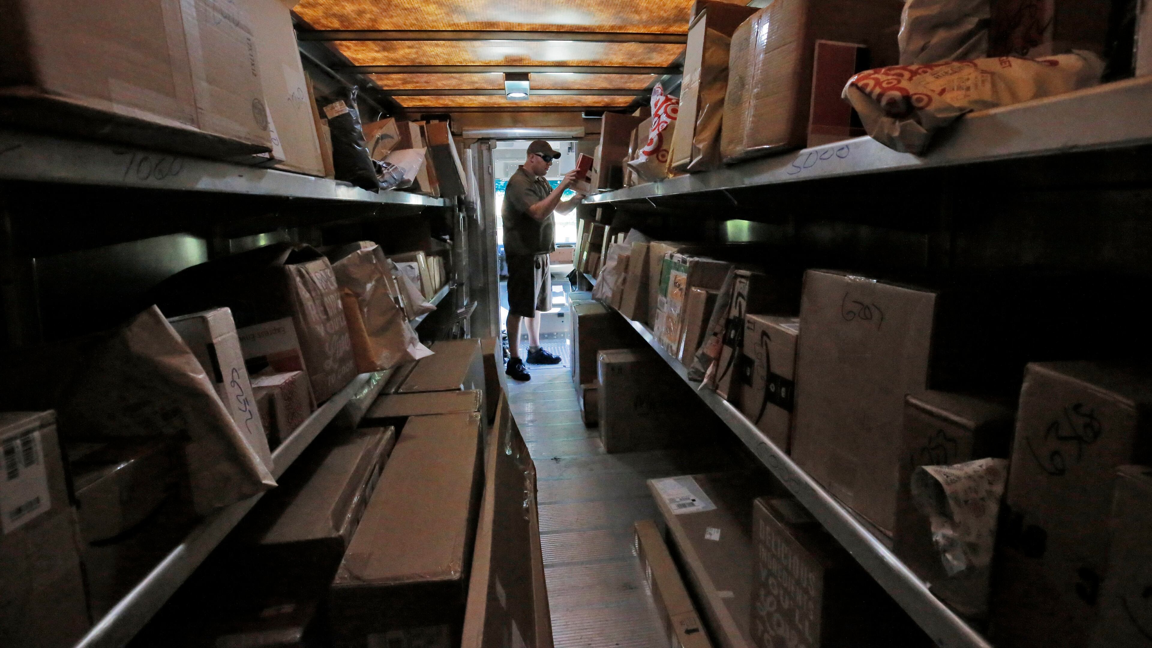 7/26/17 - Roswell, GA - In this view from the back of his truck, driver Dan Partyka's first priority is to deliver his overnight packages. As more people buy more goods online, the rapid and unrelenting expansion of e-commerce is causing real challenges for UPS. It costs more to deliver items to individual doorsteps instead of delivering a whole pallet full of goods to stores. BOB ANDRES /BANDRES@AJC.COM