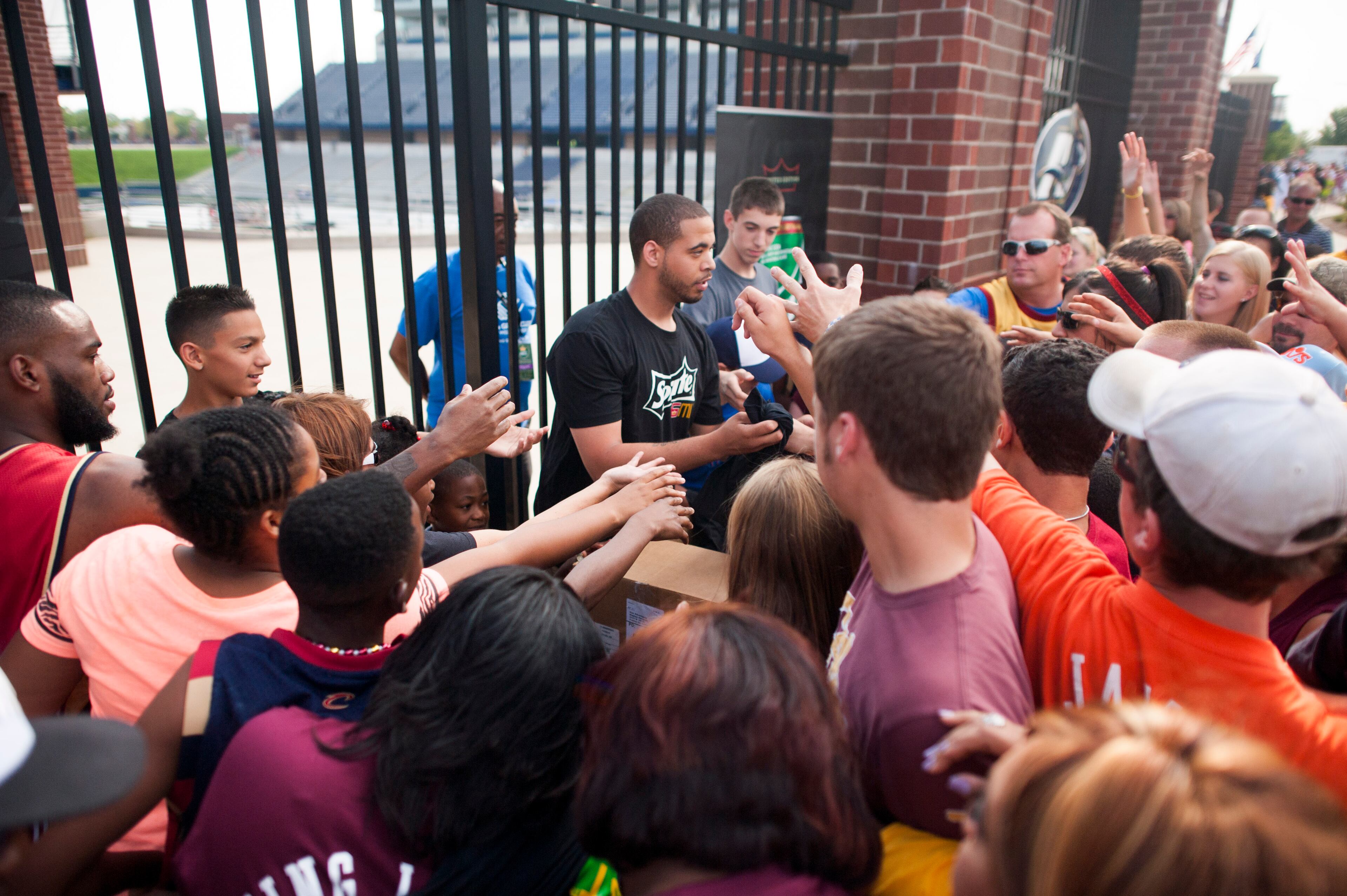 People pass out LeBron James T-Shirts at the entrance gate where people waiting to get in the Welcoming Home Ceremony for LeBron James back to the Cleveland Cavaliers at InfoCision Stadium at The University of Akron on August 8, 2014 in Akron, Ohio. (Photo by Ty Wright/Getty Images)