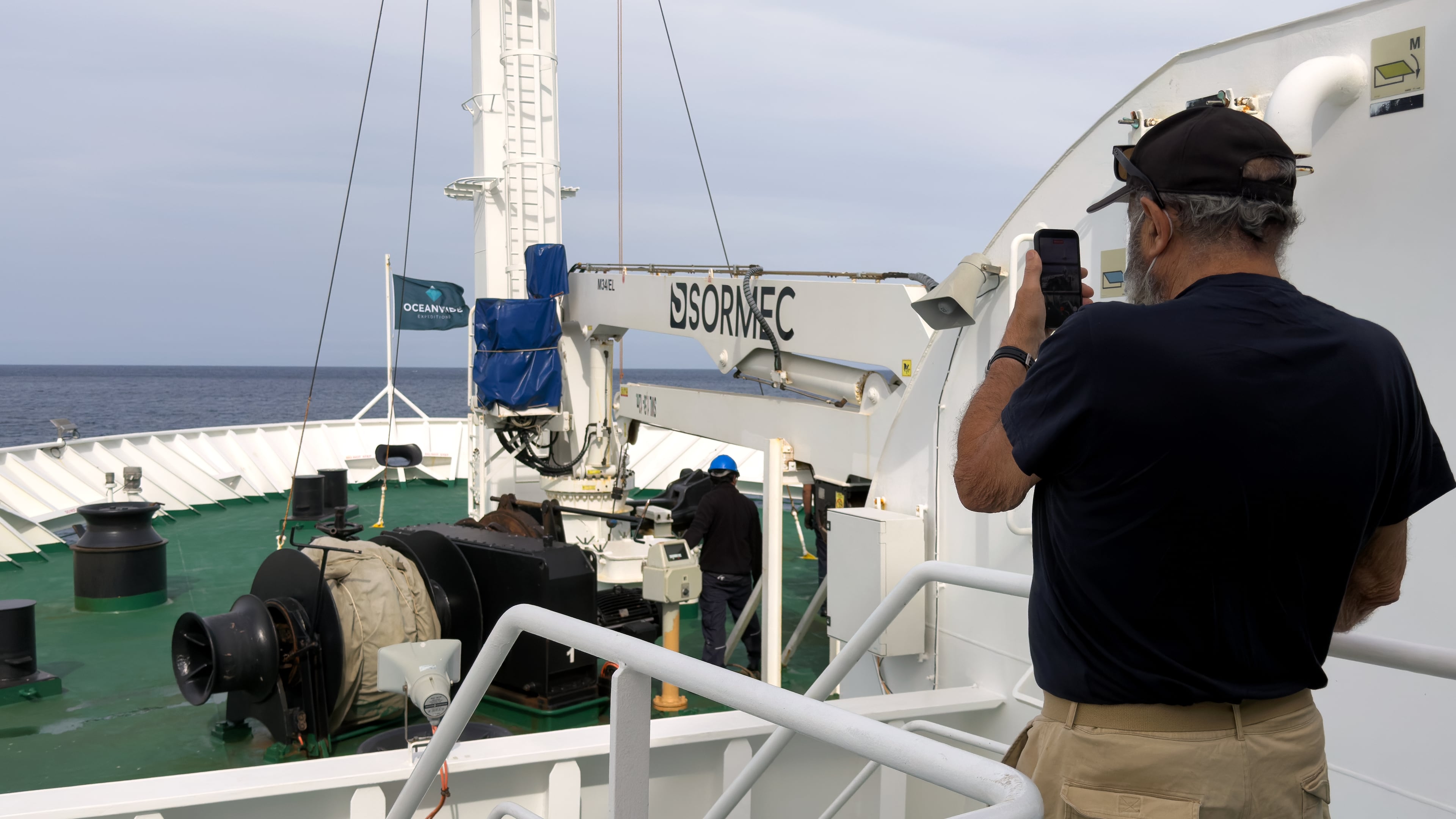 A passenger on the the hantavirus-stricken cruise ship, MV Hondius, takes a photo of the ship's weighing anchor in Praia, during the voyage to Spain's port of Tenerife, May 6, 2026. (AP Photo)
