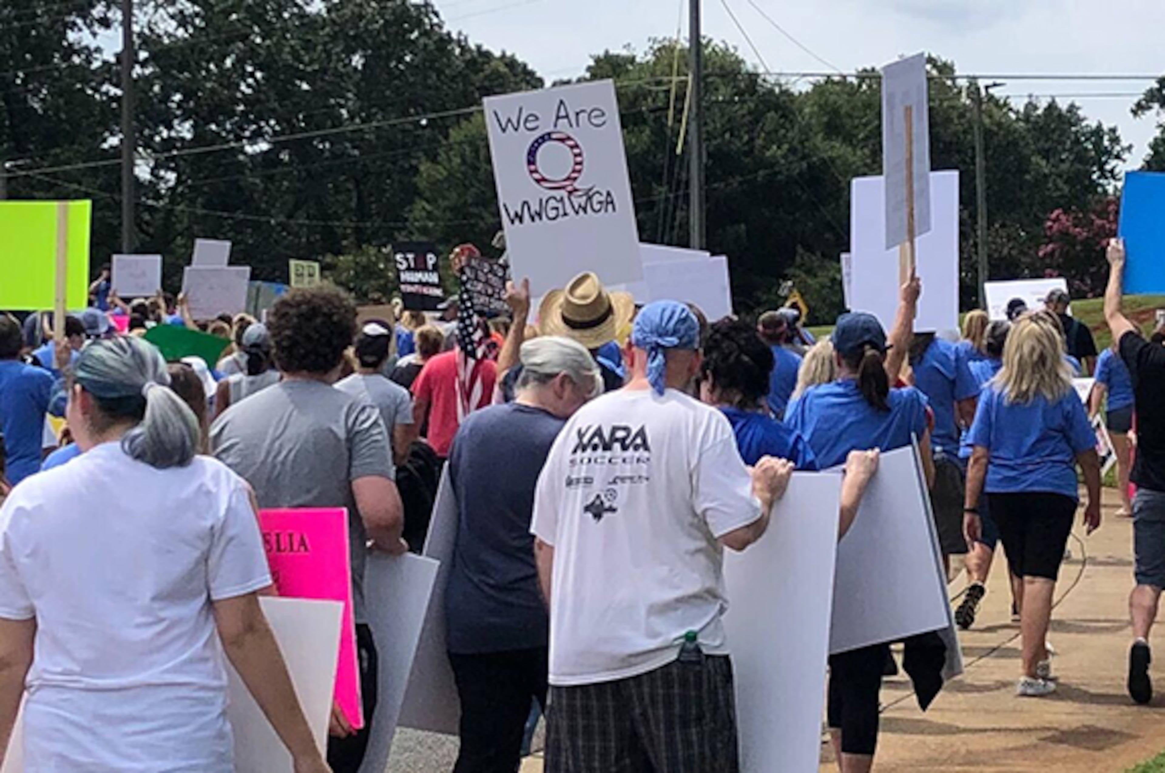 While most marchers carried signs generically in opposition to child sex trafficking, a dozen or so ignored organizers' requests not to carry QAnon posters at the Woodstock event on Saturday, Aug. 22, 2020. A "We Are Q" sign can be seen in this portion of the march. (Photo: Chris Joyner/AJC)
