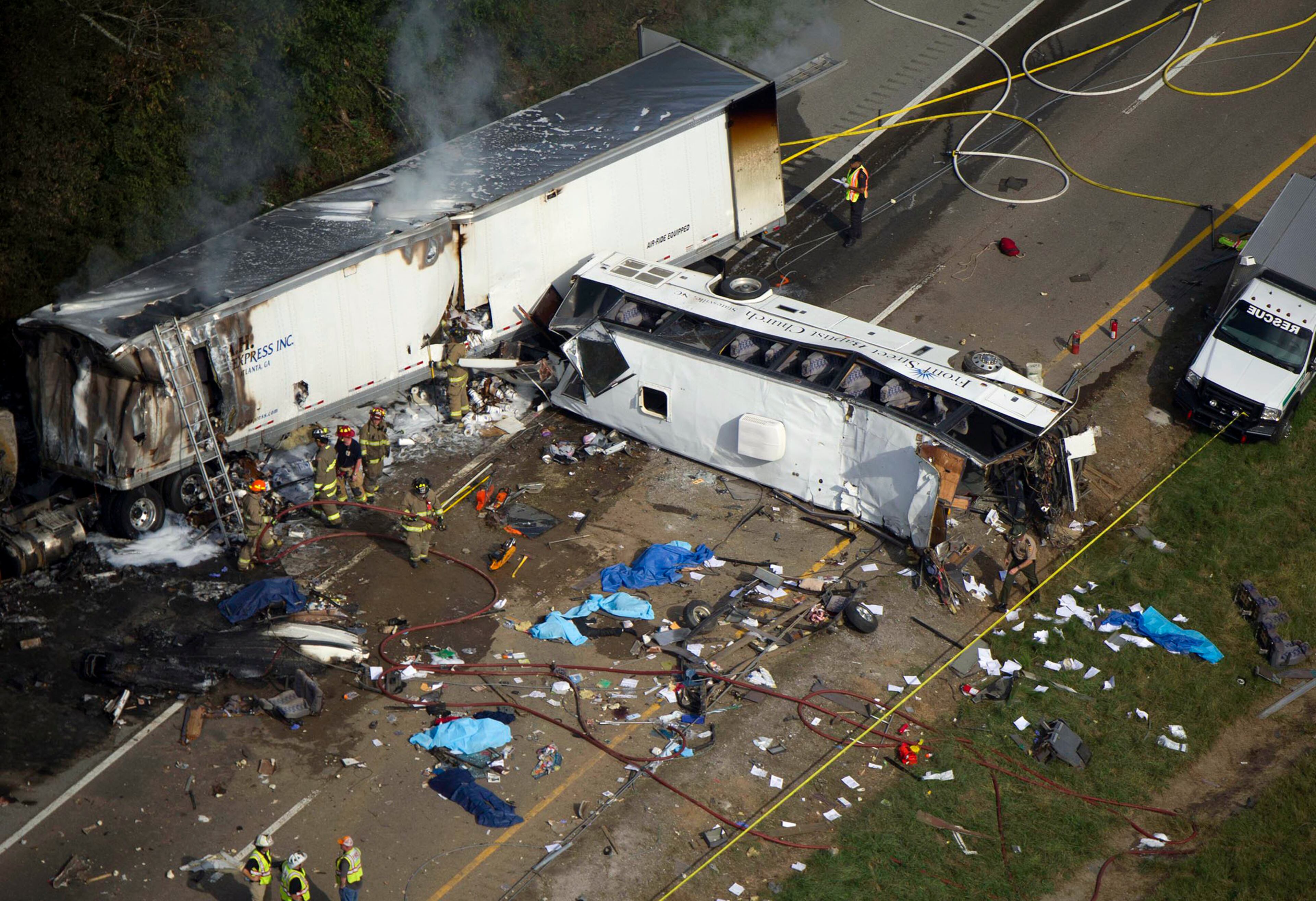 In this aerial photo, emergency workers respond to a crash involving a passenger bus and a tractor-trailer near Dandridge, Tenn., on Wednesday, Oct. 2, 2013. A spokeswoman for Tennessee's Safety Department said the bus was traveling in northeast Tennessee when it crossed the median and struck the other two vehicles. The tractor-trailer caught fire and the bus overturned. (AP Photo/The Knoxville News Sentinel, Paul Efird)