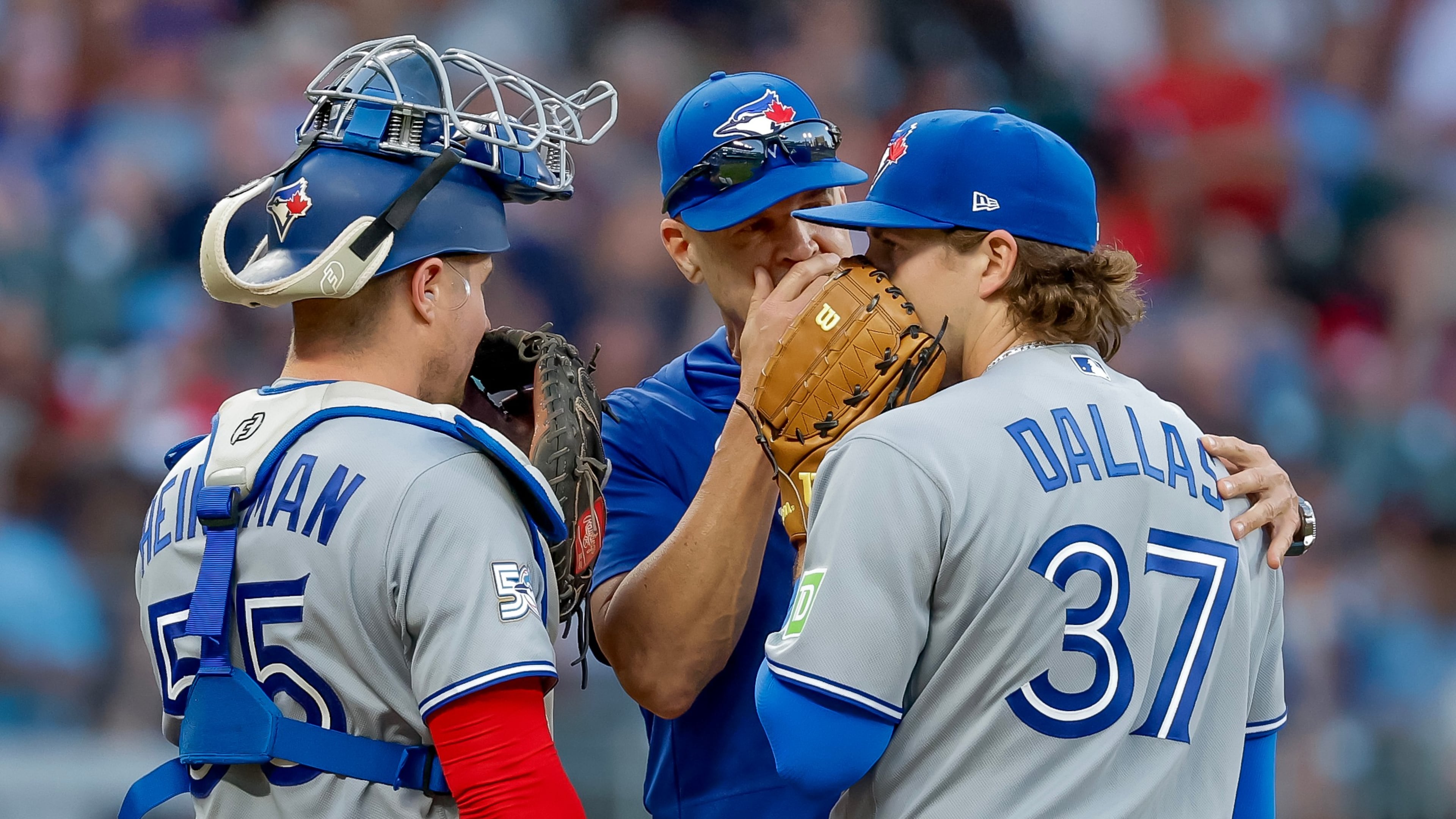 Toronto Blue Jays pitching coach Pete Walker, center, speaks with pitcher Chad Dallas (37) and catcher Tyler Heineman (55) during the third inning of a baseball game against the Atlanta Braves, Thursday, June 4, 2026, in Atlanta. (AP Photo/Erik S. Lesser)