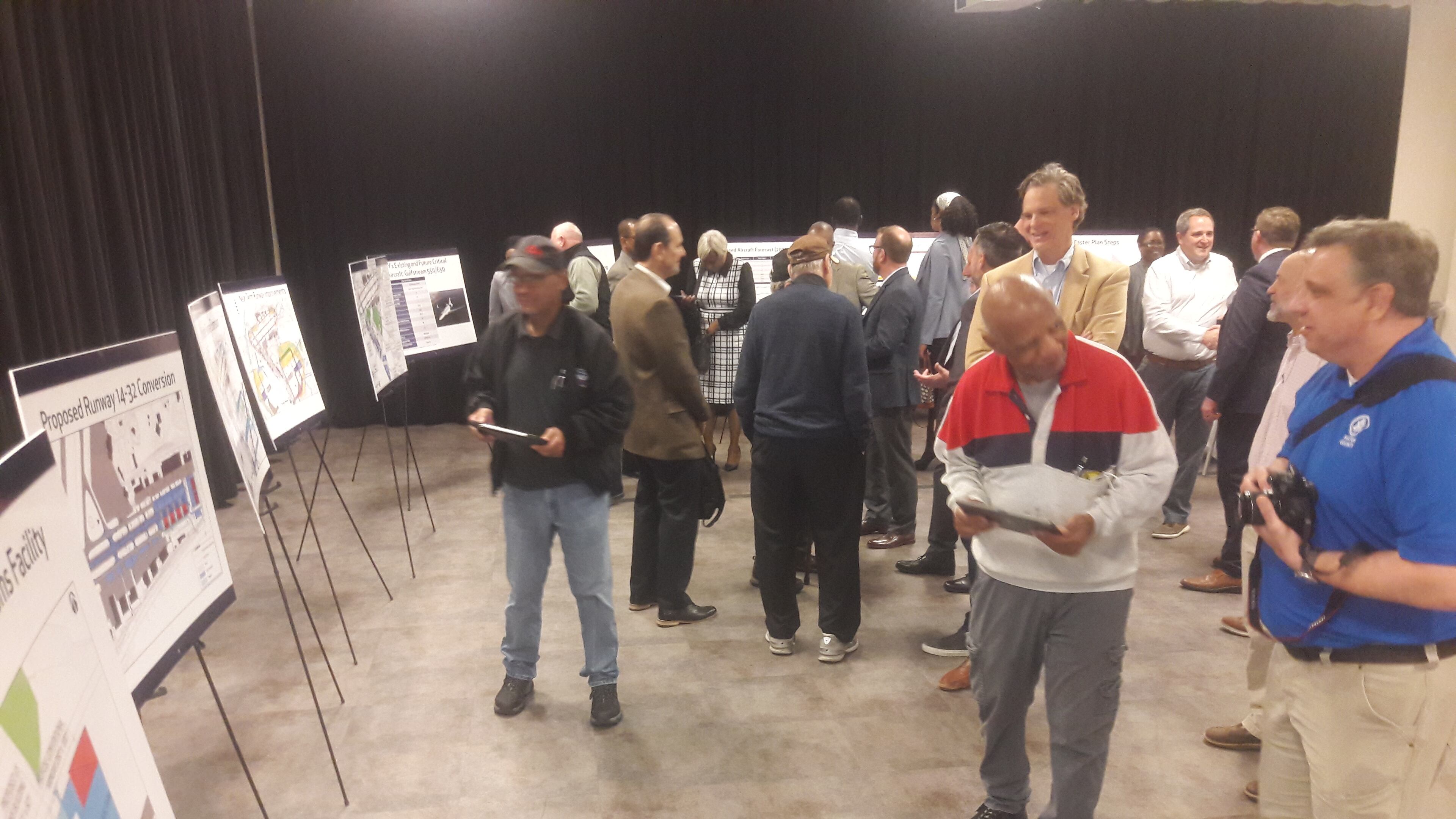 Consultants and stakeholders at Fulton County Executive Airport look over plans to lengthen the main runway and replace the crosswind runway with hangars at a public meeting Feb. 16, 2023,