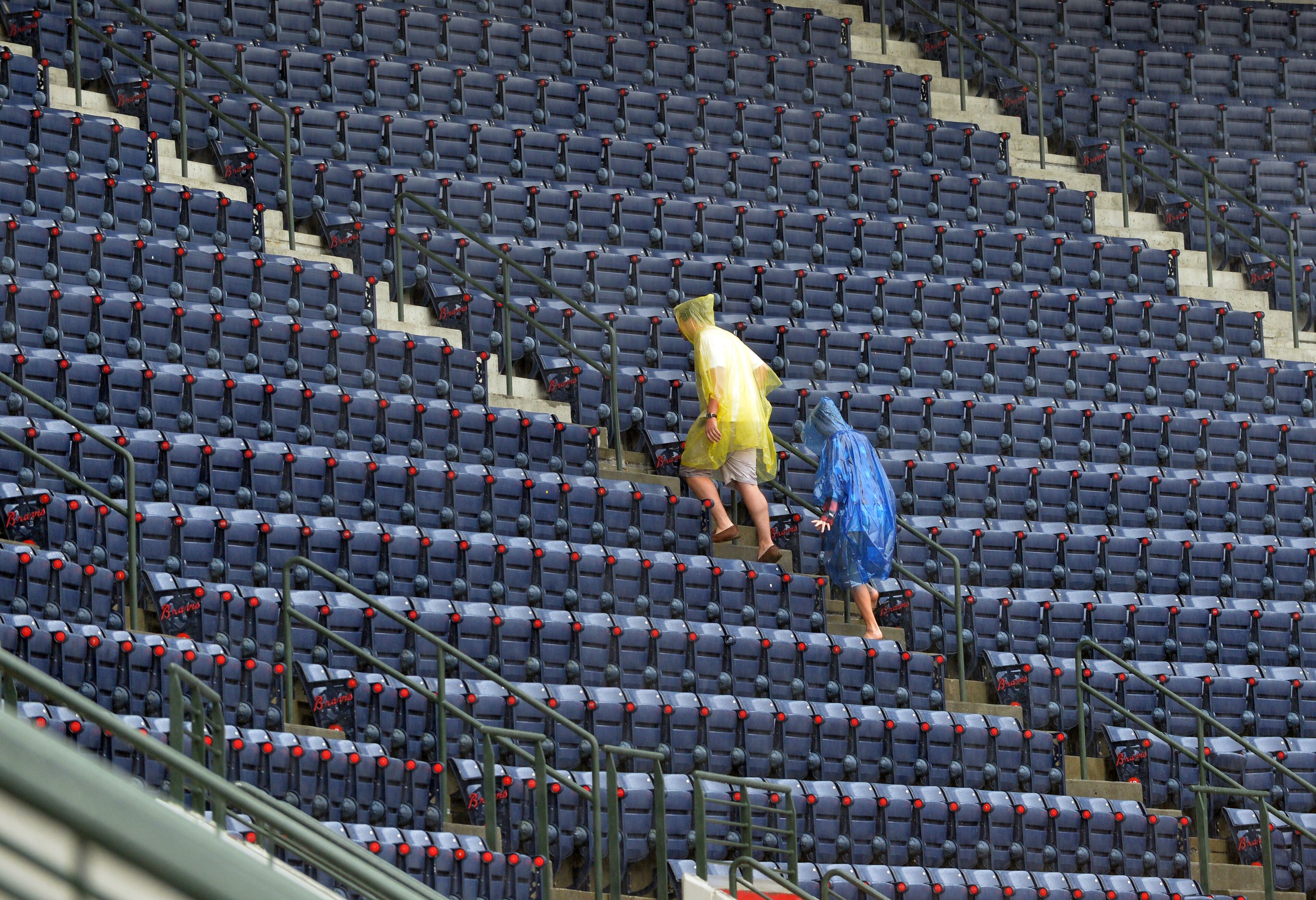 Fans run for shelter from the rain before the start of the Atlanta Braves game at Turner Field Friday May 9, 2014. The Braves are scheduled to play the Chicago Cubs tonight at 7:35pm. BRANT SANDERLIN /BSANDERLIN@AJC.COM