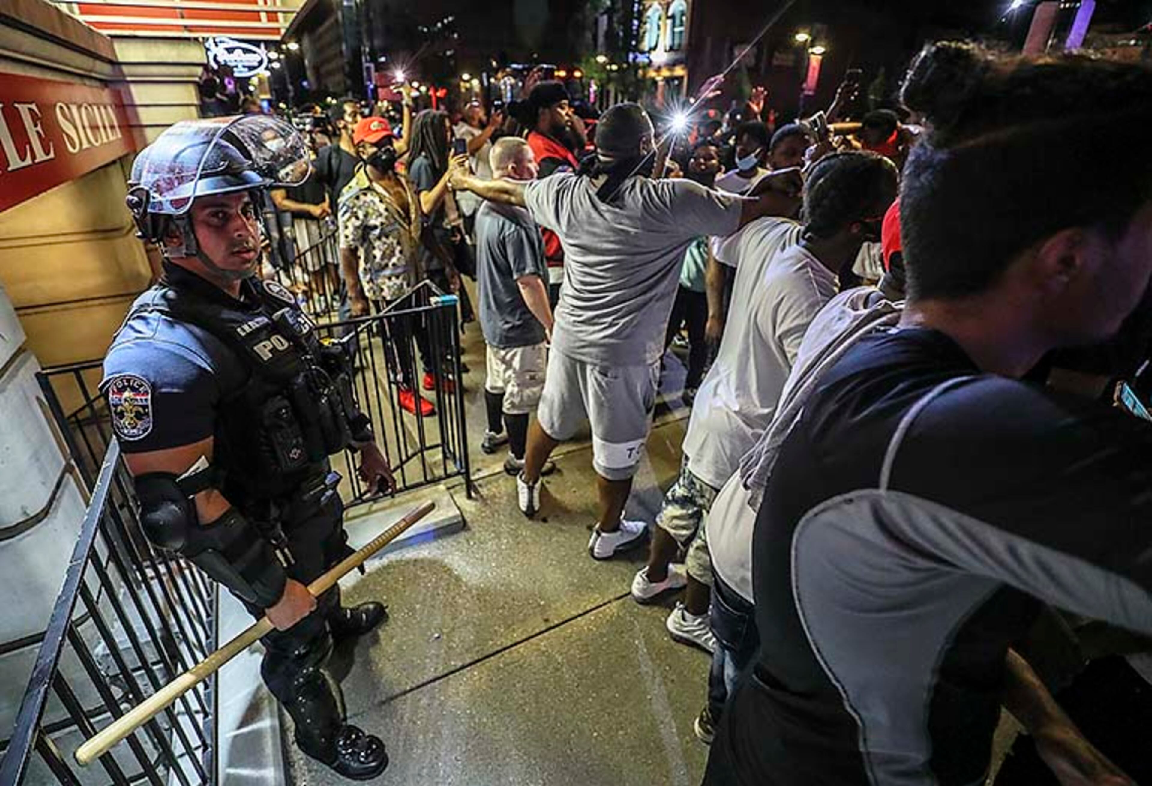 Protesters surround an LMPD officer in front of Bearno's during a protest for Breonna Taylor, Thursday, May 28, 2020 in Louisville, Ky. Taylor,â a black woman, was fatally shot by police in her home in March. The protest organizers surrounded the officer and joined arms to make sure that the crowed did not touch him. (Michael Clevenger/Courier Journal via AP)