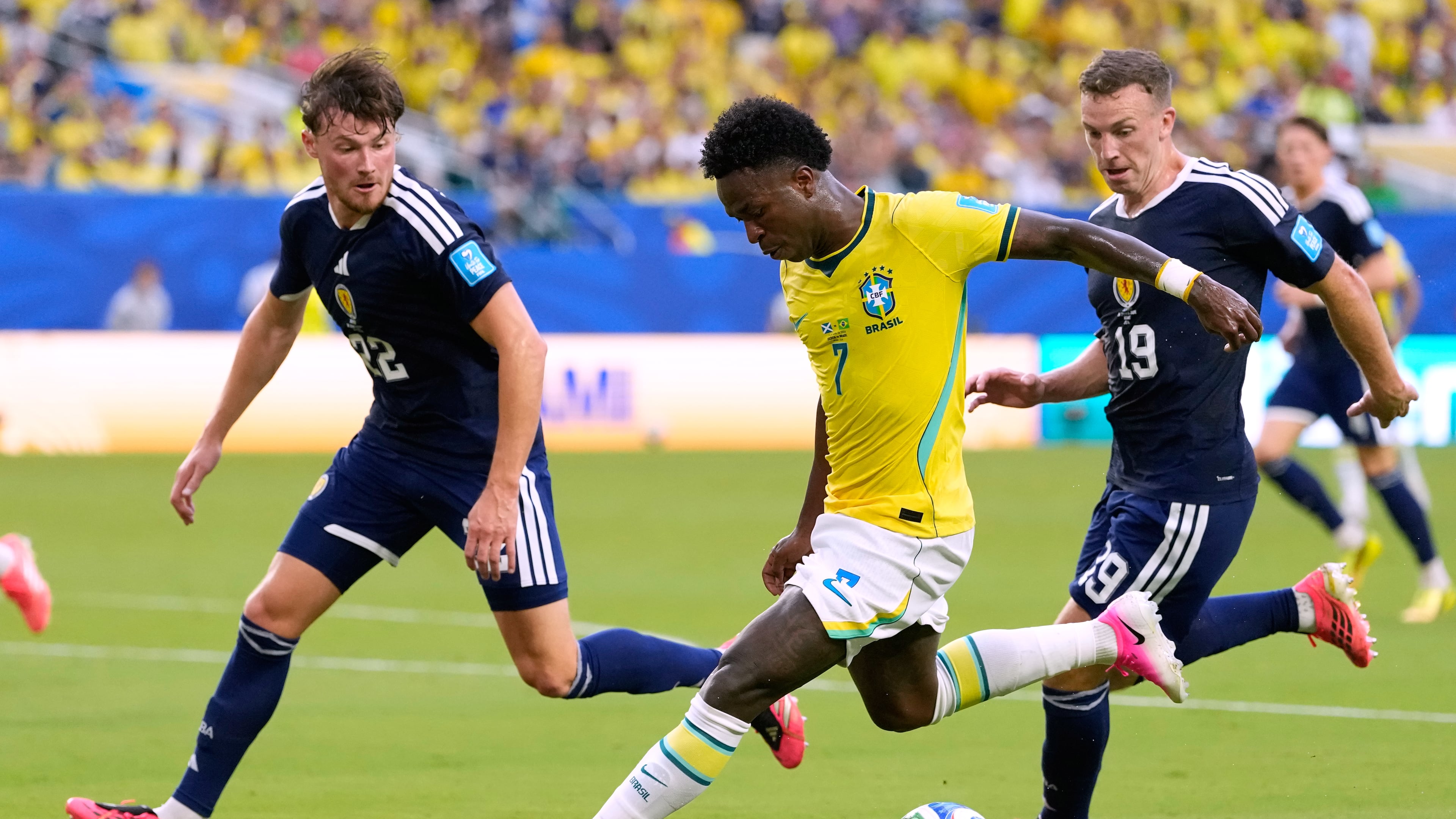 Brazil's Vinicius Junior (7) battles for the ball with with Scotland's Nathan Patterson (22) and Lewis Ferguson (19) during the World Cup Group C soccer match between Scotland and Brazil in Miami Gardens, Fla., Wednesday, June 24, 2026. (AP Photo/Rebecca Blackwell)