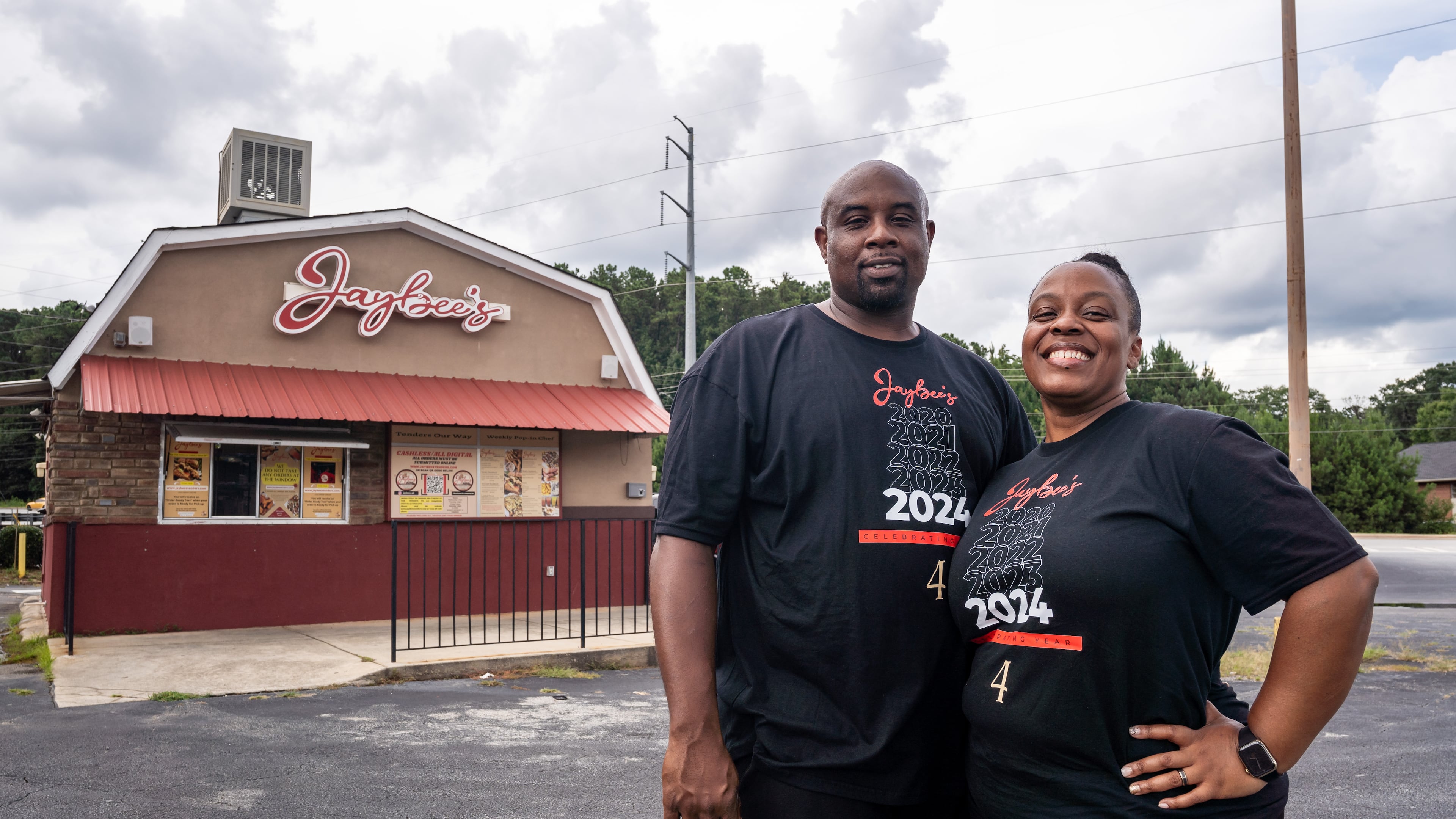 Jaybee’s Tenders co-founders Erika Harrington and her husband William Harrington pose for a portrait outside the restaurant in Decatur, GA on Thursday, July 25, 2024. (Seeger Gray / AJC)
