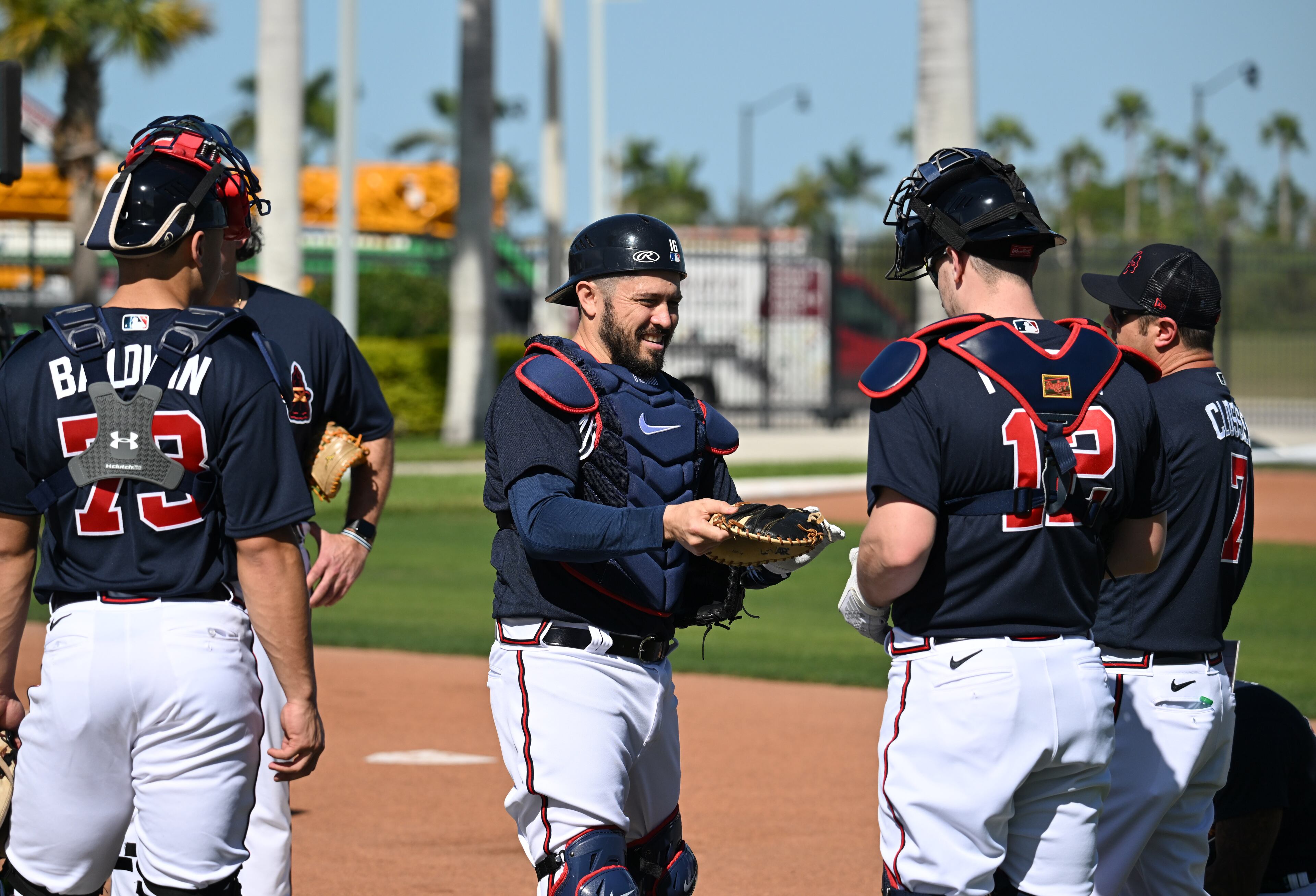 Braves catcher Travis d'Arnaud (center) talks with his teammates during spring training Thursday at CoolToday Park in North Port, Florida. (Hyosub Shin / Hyosub.Shin@ajc.com)