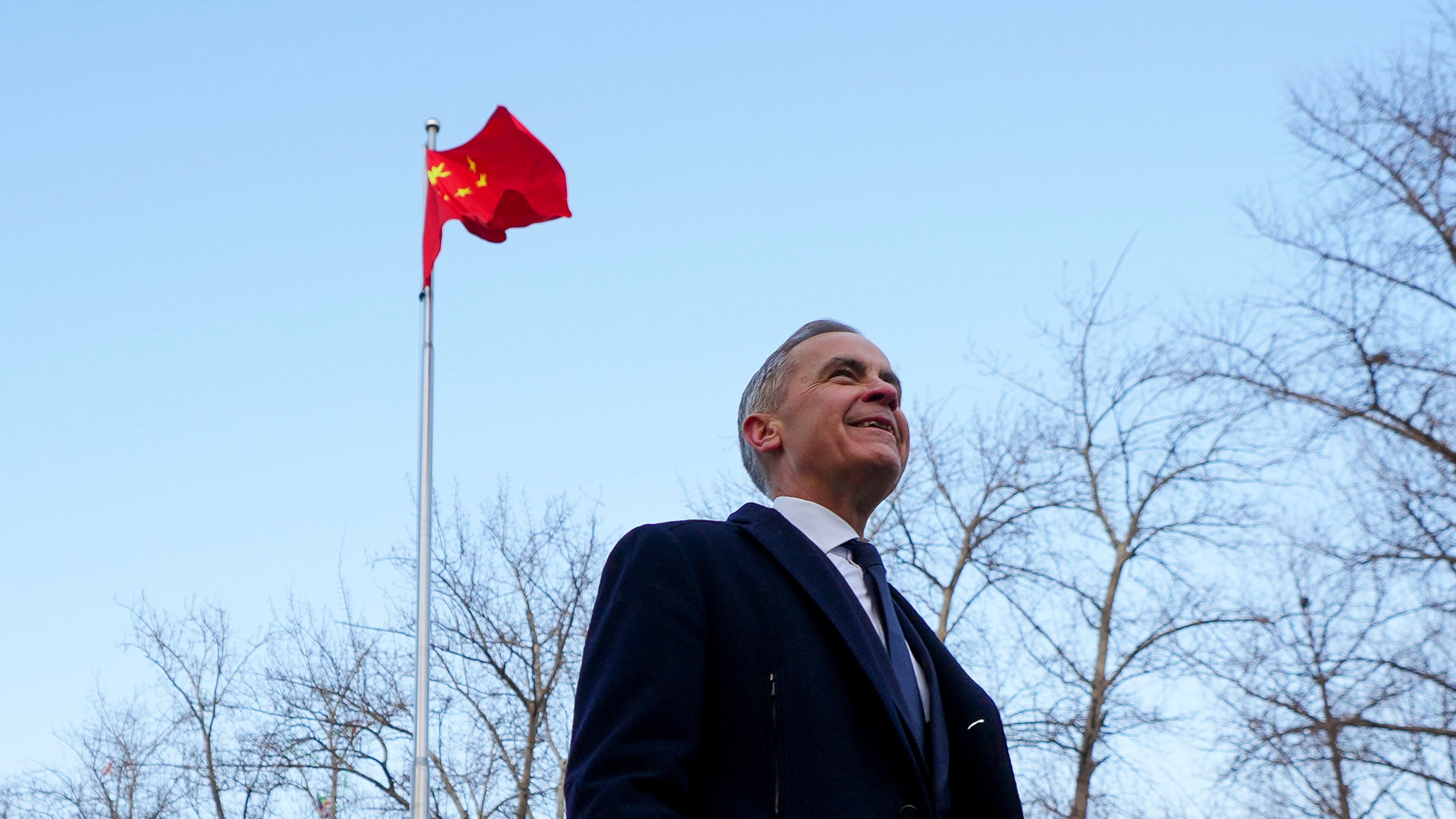 Prime Minister Mark Carney walks past a Chinese flag as he leaves after holding a press conference in Ritan Park in Beijing, China on Friday, Jan. 16, 2026. (Sean Kilpatrick /The Canadian Press via AP)