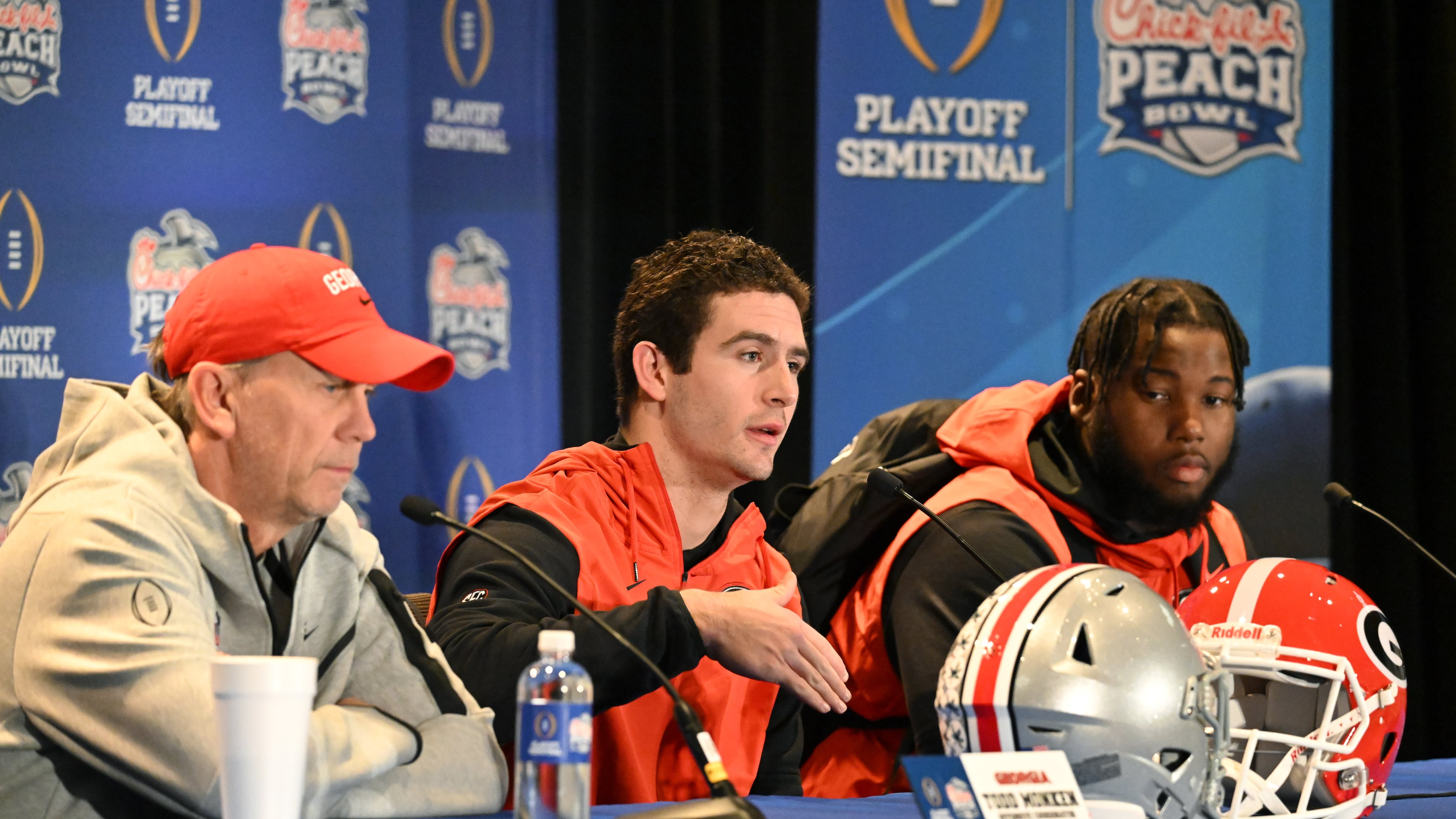 Georgia's quarterback Stetson Bennett (center) speaks to members of the press as he sits with offensive coordinator Todd Monken (left) and offensive lineman Sedrick Van Pran (right) during press conference at The Westin Peachtree Plaza in Atlanta on Wednesday, Dec. 28, 2022. (Hyosub Shin/AJC)