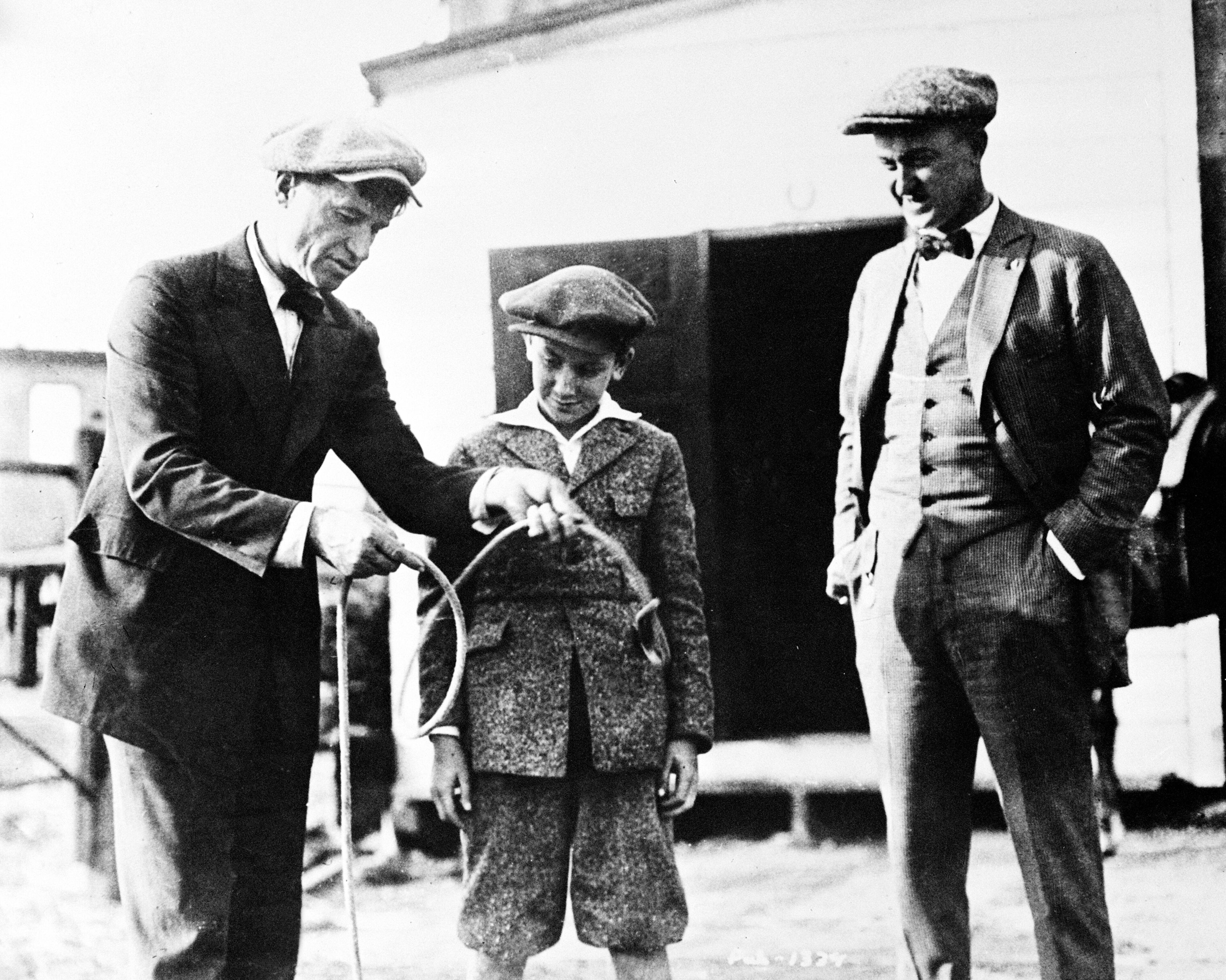 Humorist Will Rogers explains one of his rope tricks for baseball great Ty Cobb, right, and his son, Ty Cobb Jr., in this 1920 photograph. (AP Photo)