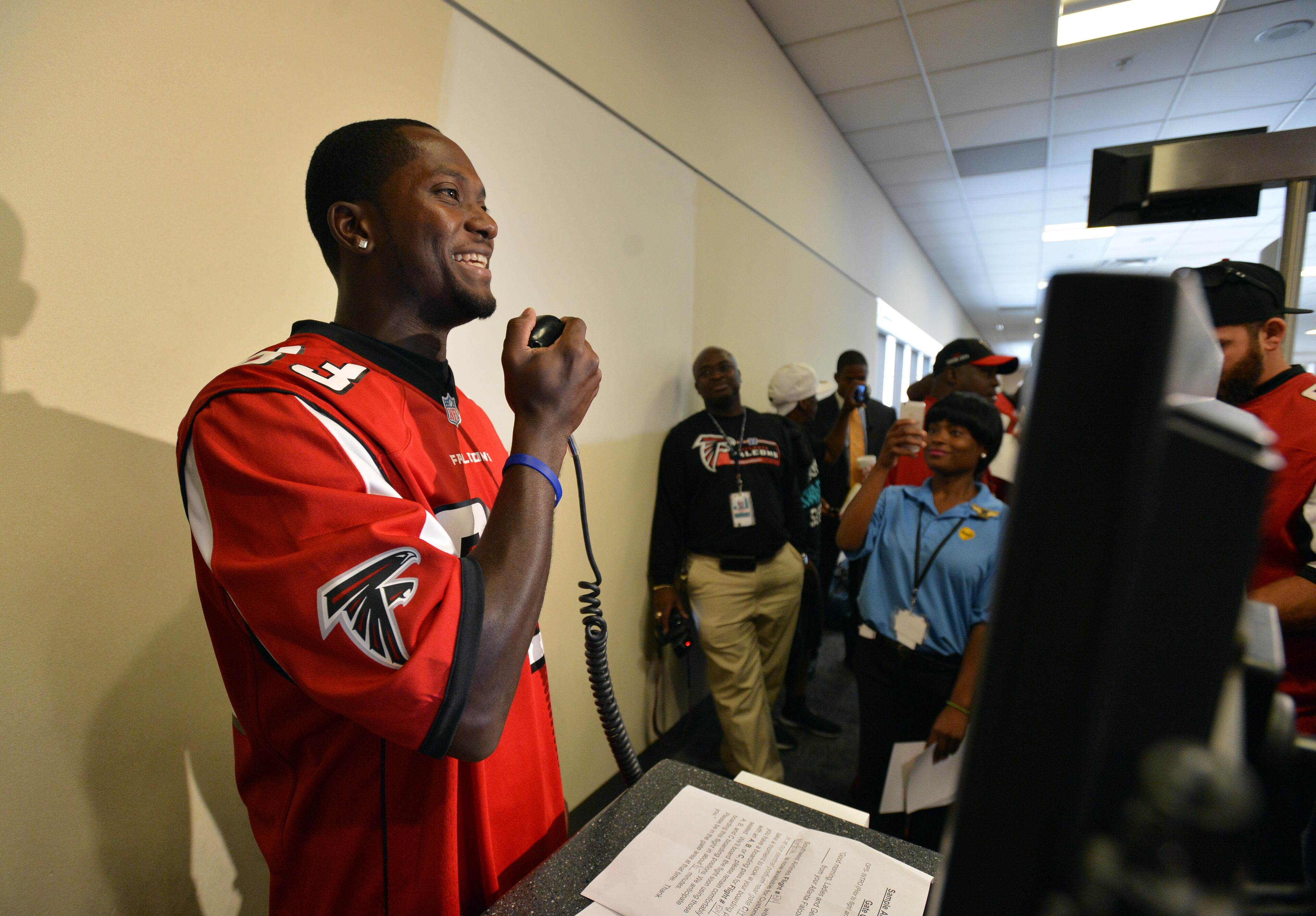 Atlanta Falcons receiver Harry Douglas gives a pre-boarding announcement at a Southwest Airlines gate. Five members of the Atlanta Falcons visited Southwest Airlines operations at Hartsfield-Jackson Atlanta International Airport with special guest Jordan Thomas. Thomas, 14, was diagnosed with cancer in 2012. As part of the Make-A-Wish Foundation, Thomas had the opportunity to hang out with members of the Falcons as they visited the Southwest ticket counter terminal, announced a flight departure and helped direct a plane away from the terminal. BRANT SANDERLIN /BSANDERLIN@AJC.COM