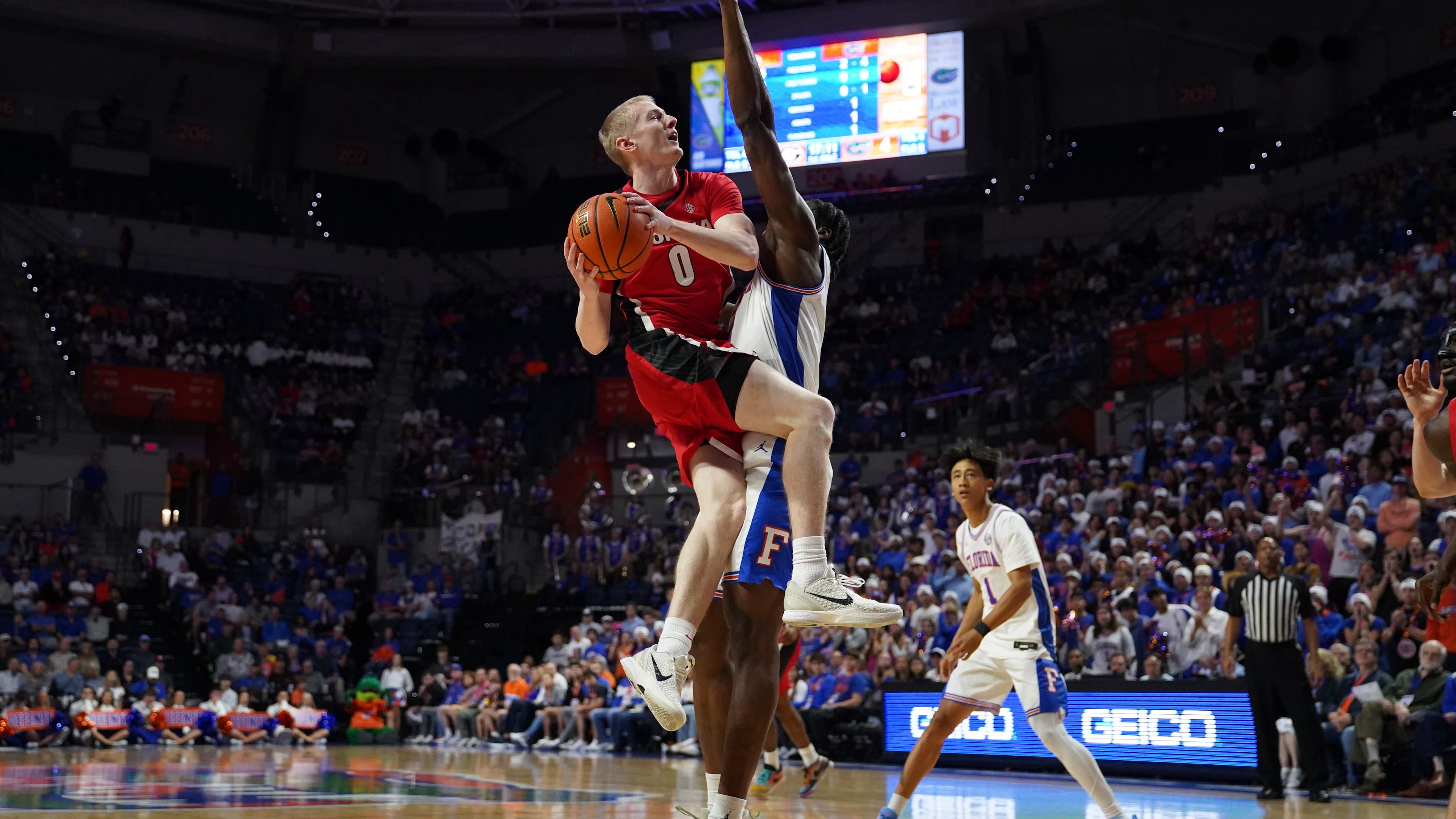 Georgia guard Blue Cain jumps to dunk the ball as Florida center Rueben Chinyelu attempts to block during the first half of an NCAA college basketball game Tuesday, Jan. 6, 2026, in Gainesville, Fla. (AP Photo/Morgan Hurd)