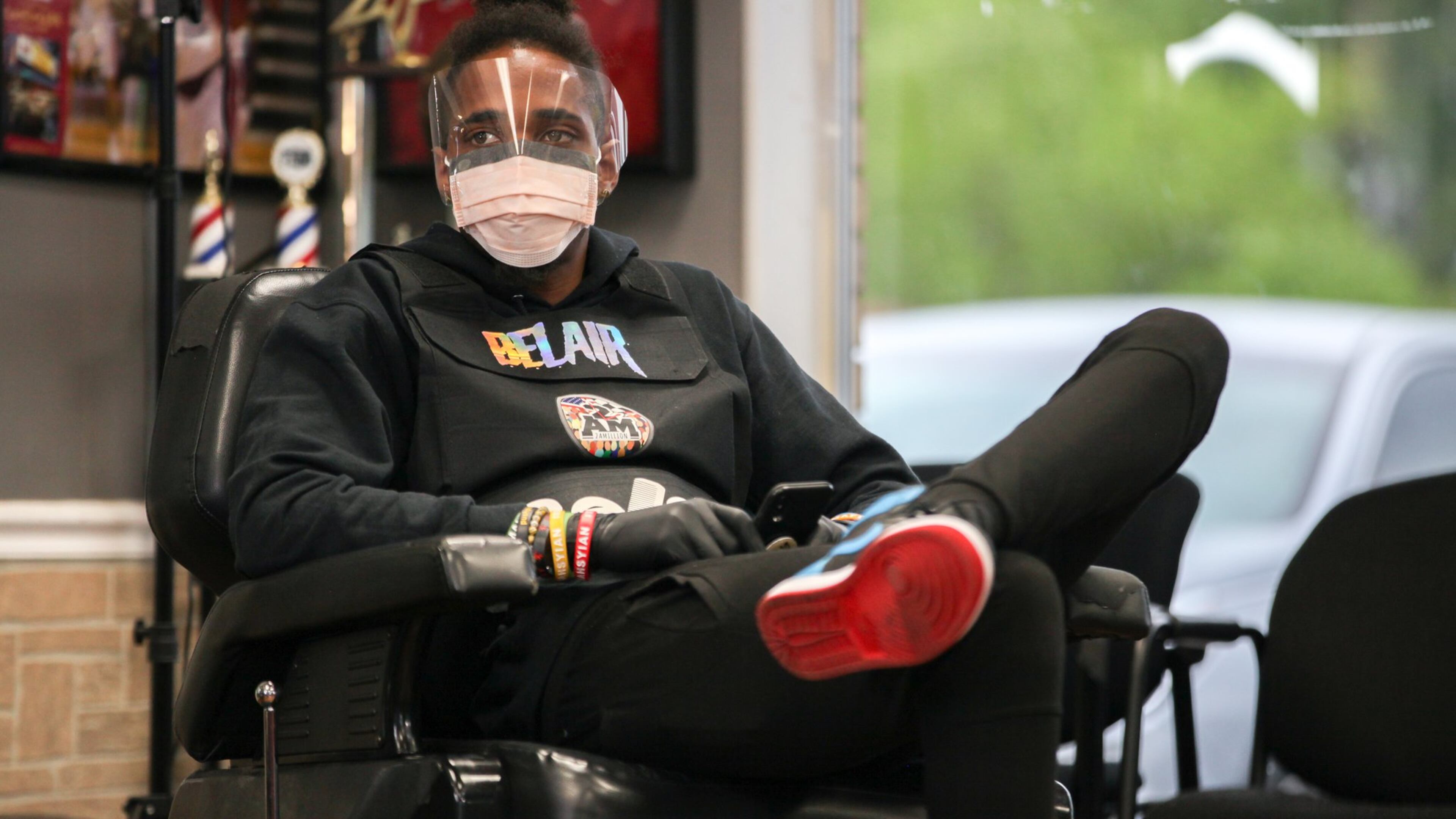 Barber Carlton O’Shea listens Wednesday in Marietta as Blessed Up Barber Shop Owner Taurean Overall, not pictured, goes over safety measures to help prevent the spread of coronavirus when they open back up on Friday. Gov. Brian Kemp is allowing certain businesses to reopen. BRANDEN CAMP/SPECIAL