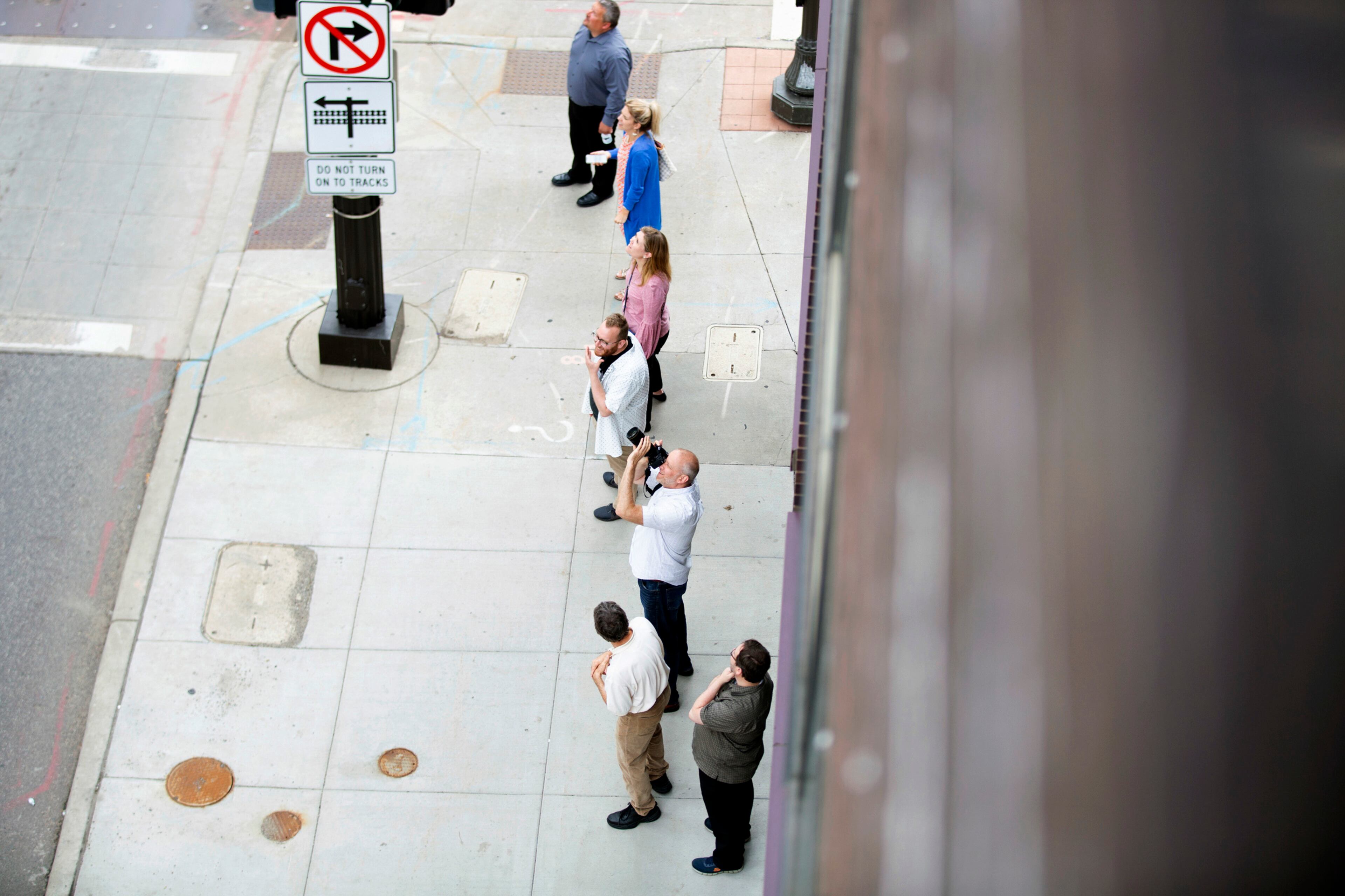 Pedestrians gather on 7th Street in St. Paul, Minn., to watch a raccoon that scaled the UBS Tower on Tuesday, June 12, 2018. (Evan Frost/Minnesota Public Radio via AP)