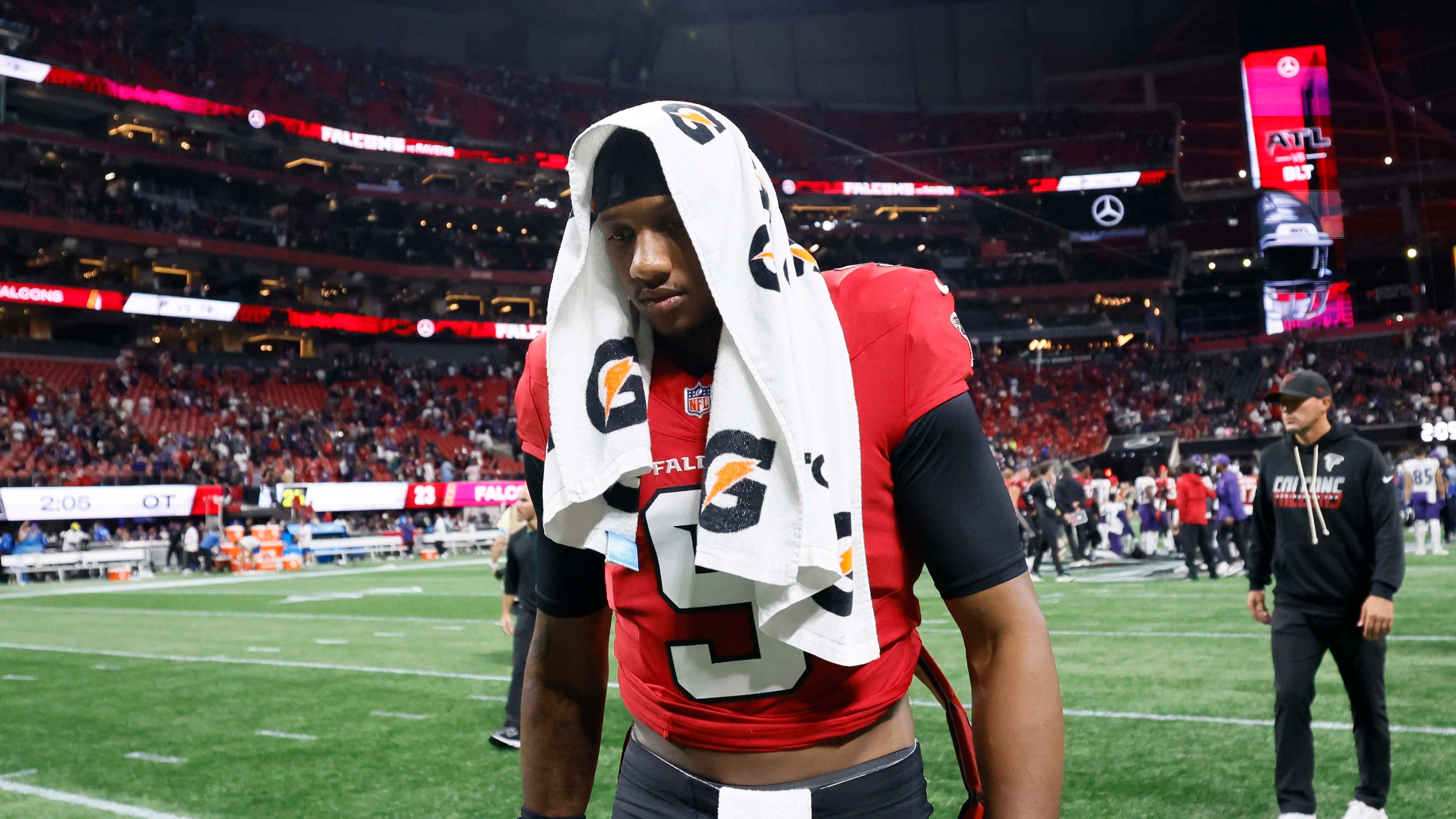 Atlanta quarterback Michael Penix Jr. leaves the field covering his head after the Falcons lose to the Baltimore Ravens 30-23 in overtime at Mercedes-Benz Stadium in Atlanta on Sunday, Oct. 11, 2026. (Miguel Martinez/AJC)