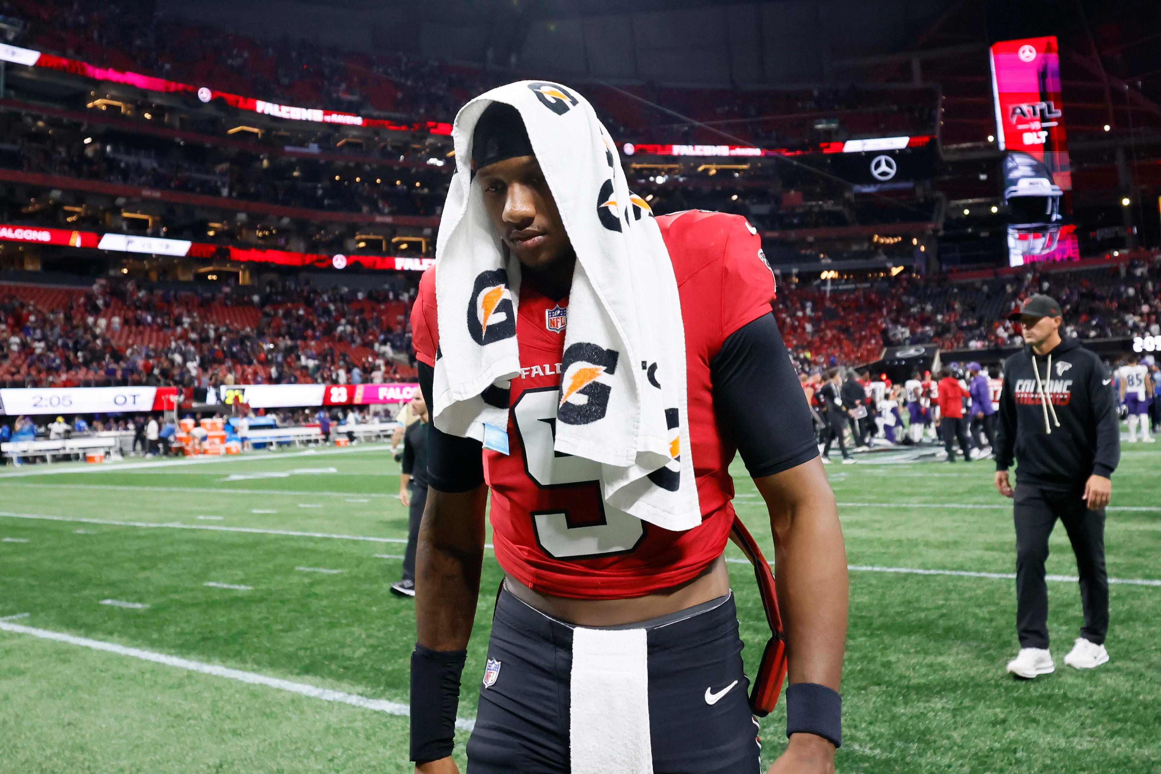 Falcons quarterback Michael Penix Jr. leaves the field with a towel over his head. (Miguel Martinez/AJC)