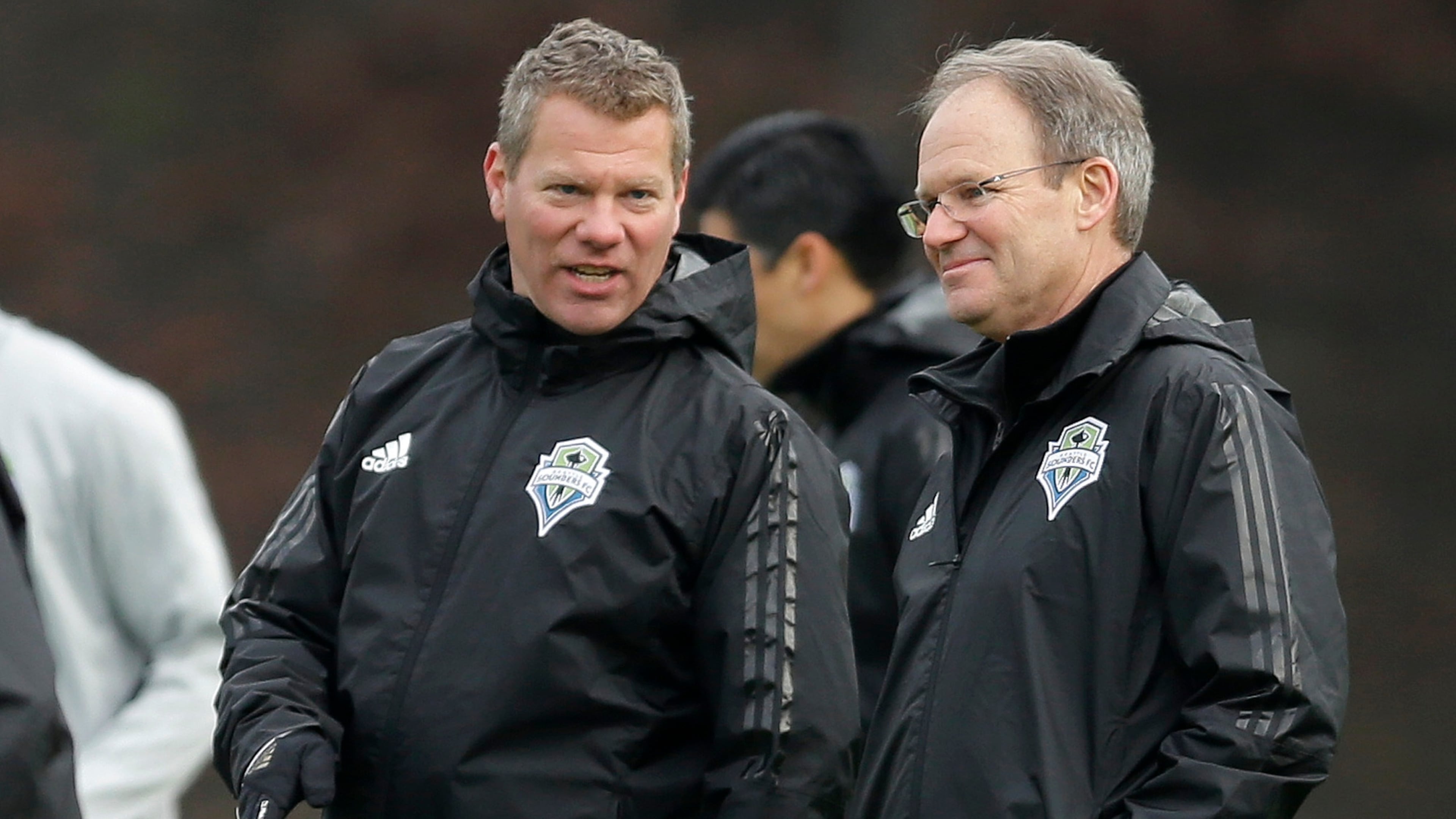 Seattle Sounders head coach Brian Schmetzer, right, talks with David Tenney, left, manager of performance and sports science, during the first training session of the 2017 MLS soccer season, Tuesday, Jan. 24, 2017, in Tukwila, Wash. (AP Photo/Ted S. Warren)