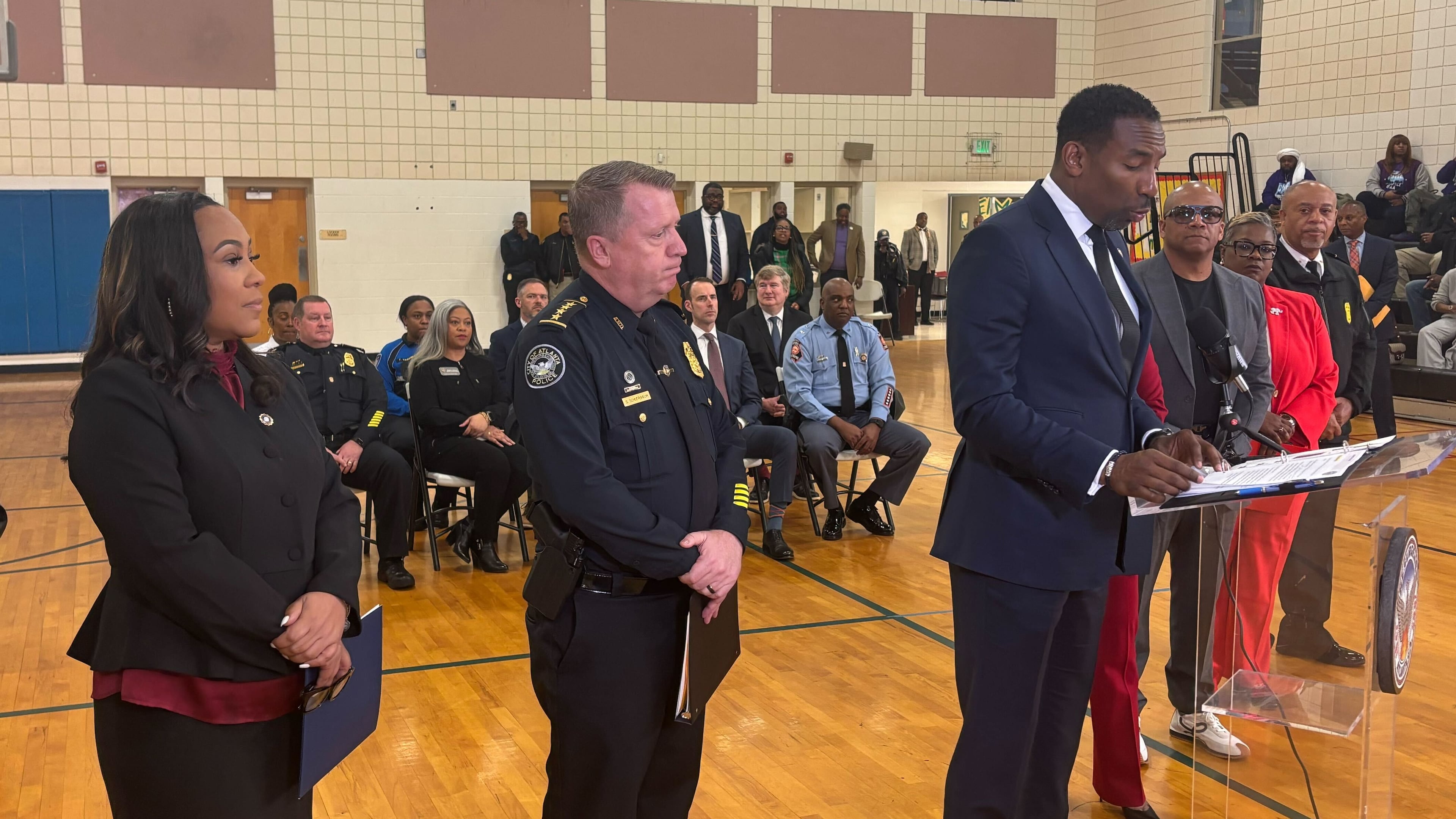 (Left to right) Fulton County District Attorney Fani Willis and Atlanta Police Chief Darin Schierbaum listen as Atlanta Mayor Andre Dickens talks about crime reduction last week. (Jozsef Papp/AJC)