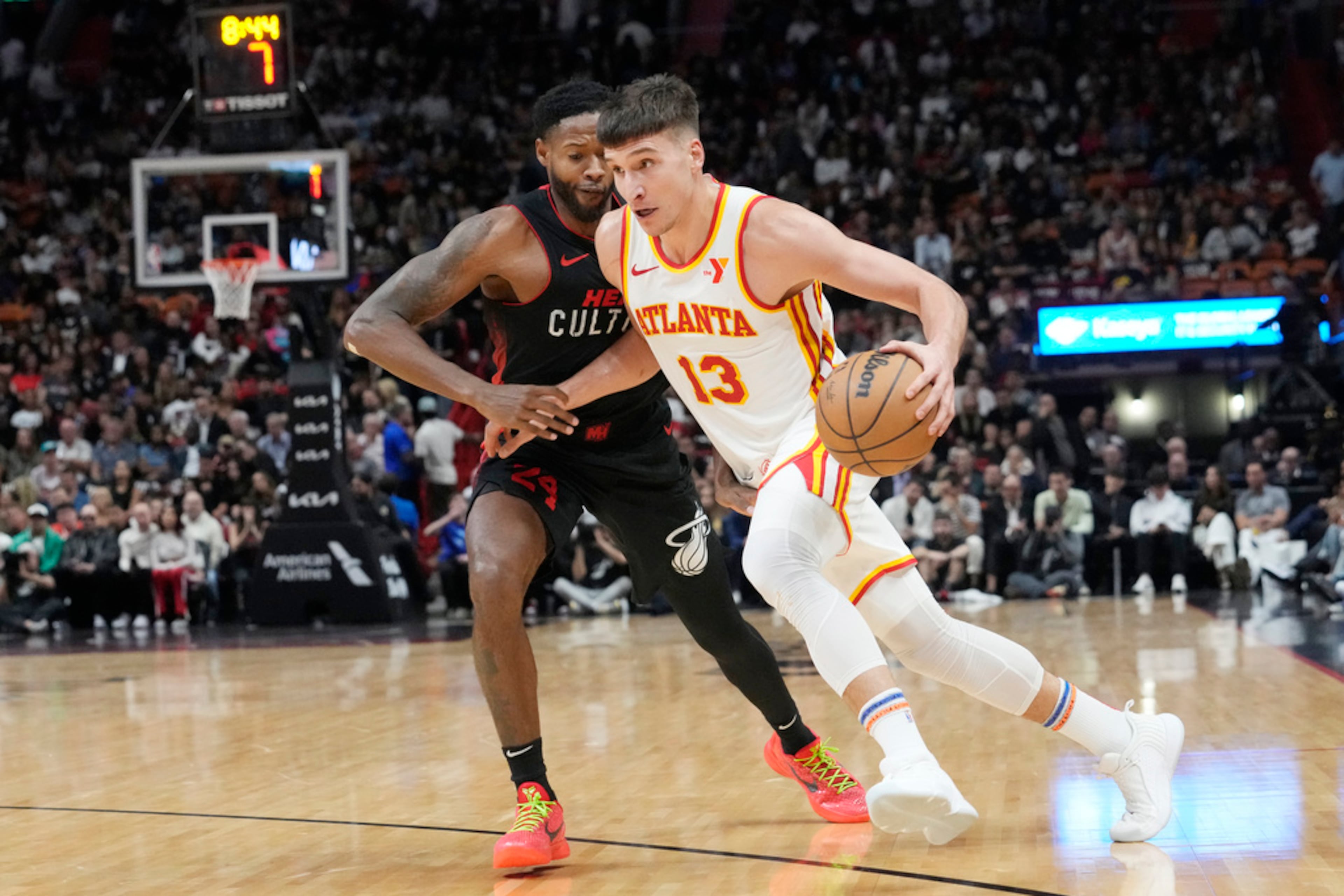 Atlanta Hawks guard Bogdan Bogdanovic (13) dribbles the ball as Miami Heat forward Haywood Highsmith (24) defends during the first half of an NBA basketball game, Friday, Jan. 19, 2024, in Miami. (AP Photo/Marta Lavandier)