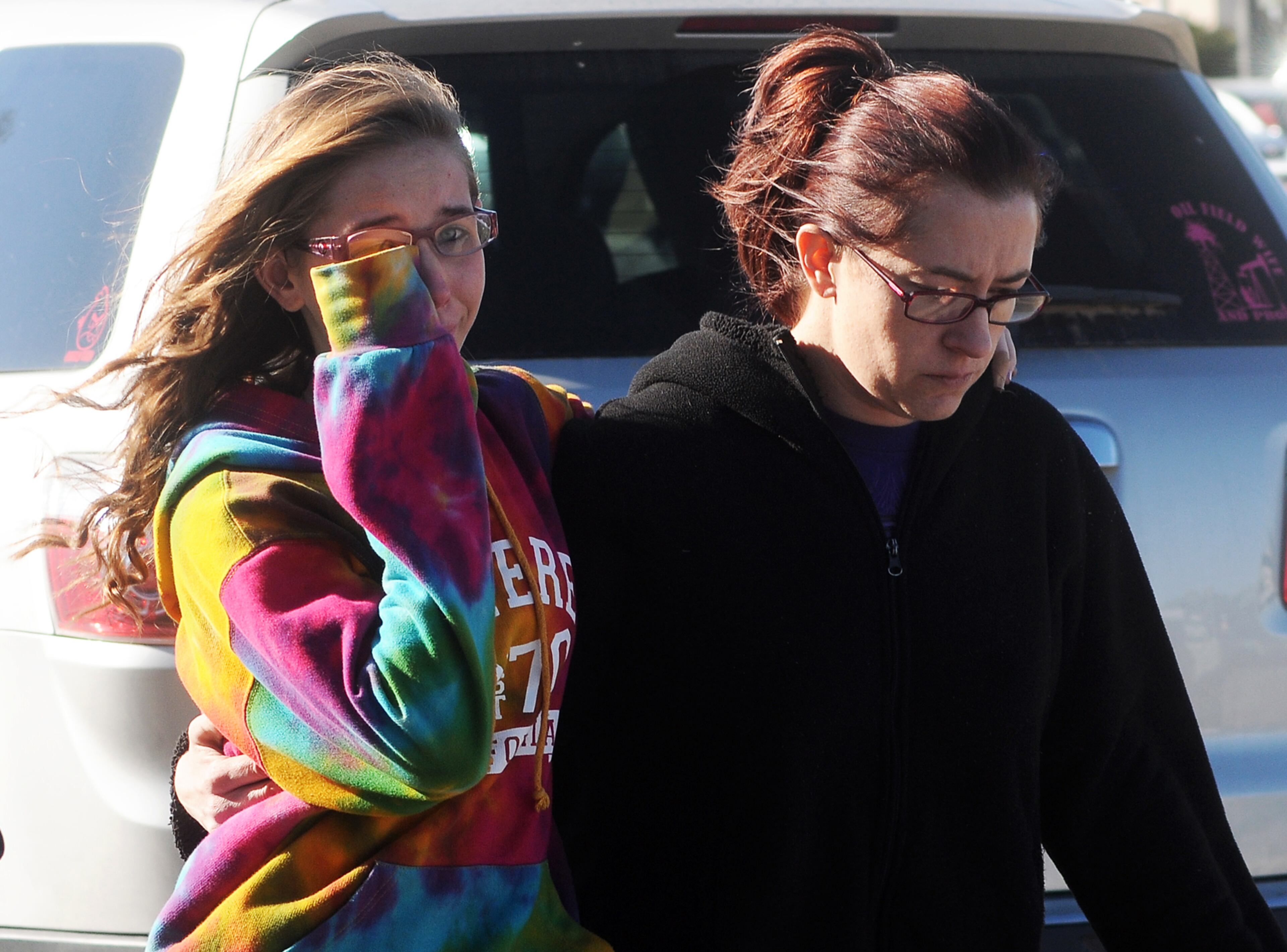 A student, left, walks with a woman at a staging ground area set up at the Roswell Mall, where families were united after a shooting at Berrendo Middle School on Jan. 14, 2014, in Roswell, N.M.