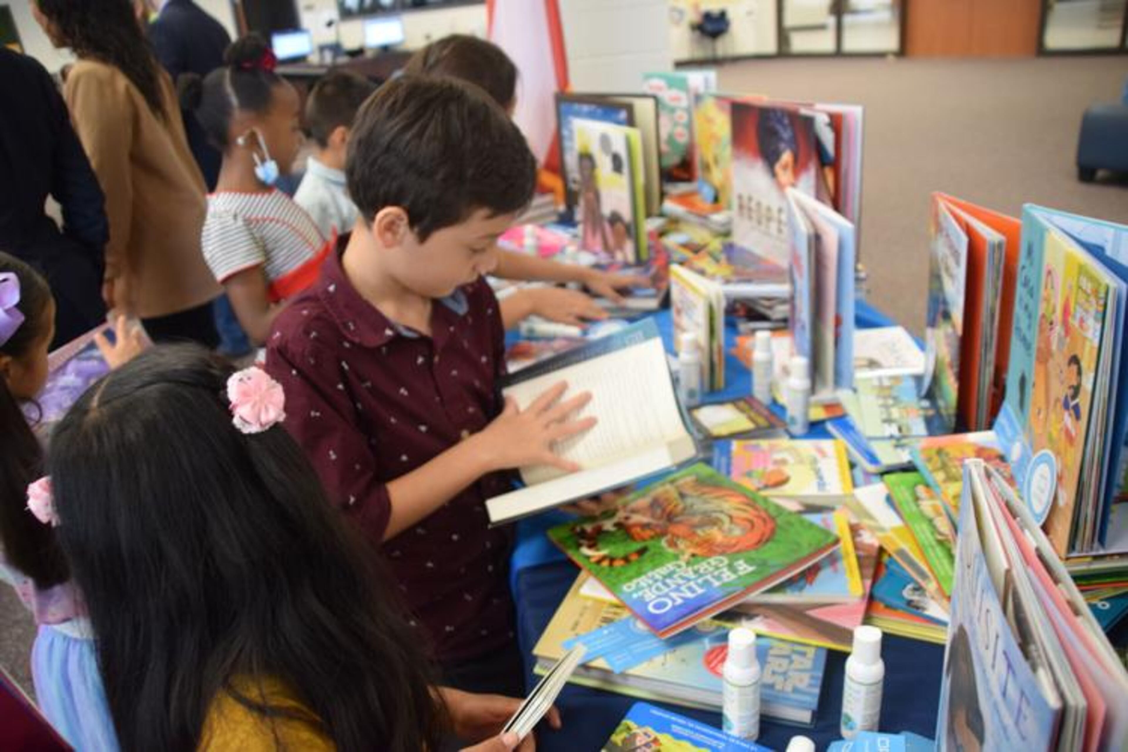 Graves Elementary School students check out some of the multilingual books that literacy education nonproft Preface donated to the school's library. (Courtesy of Curt Yeomans)