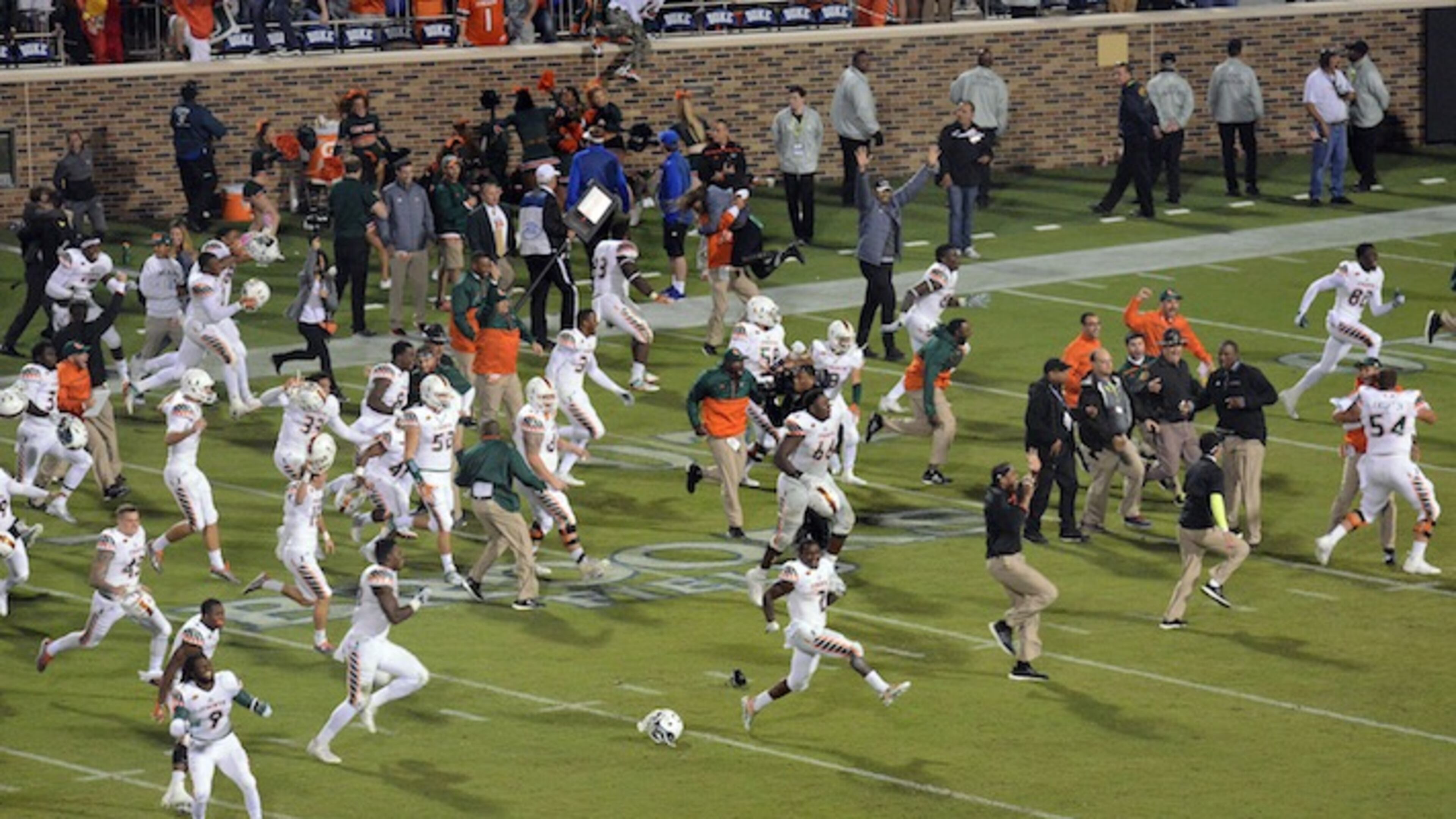 Miami players run onto the field to celebrate their 30-27 win over Duke in the final seconds of an NCAA college football game in Durham, N. C. (Bernard Thomas/The Herald-Sun via AP)