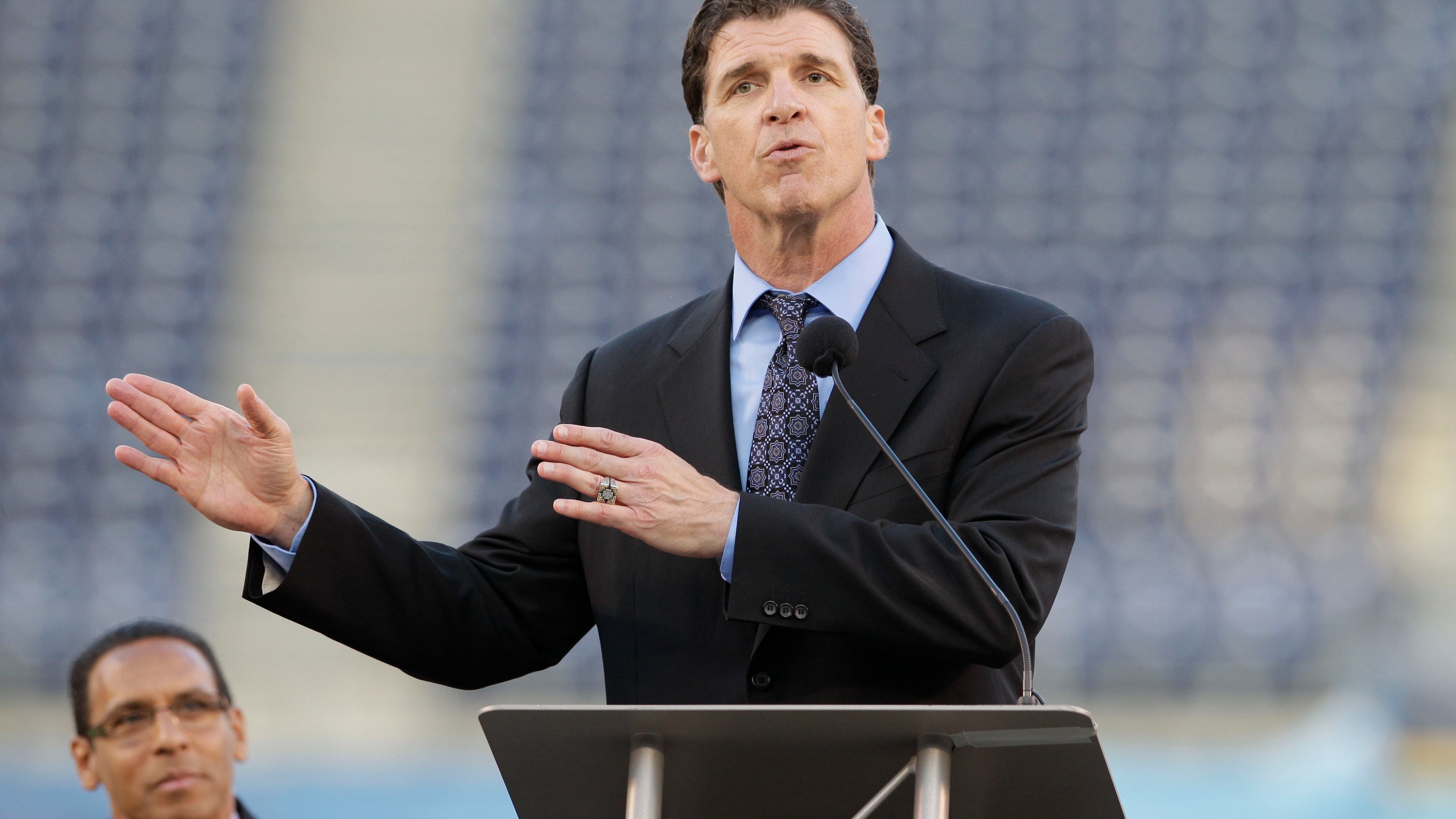FILE - Former San Diego Chargers linebacker Billy Ray Smith Jr. gestures during a public memorial service for football player Junior Seau at Qualcomm Stadium, May 11, 2012, in San Diego. (AP Photo/ Gregory Bull, File)