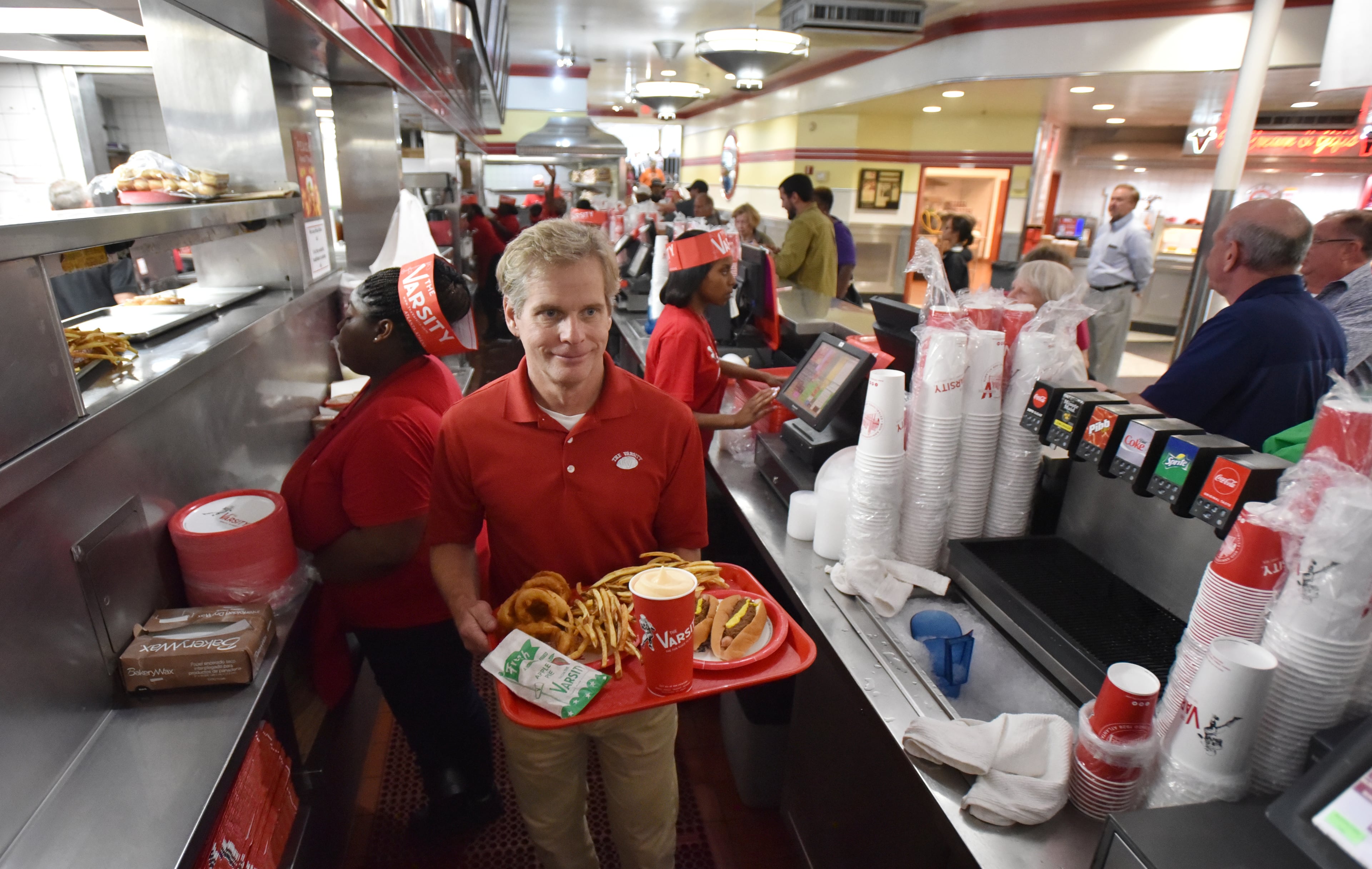 August 2, 2018 Atlanta - Gordon Muir, president, prepares a tray at the Varsity in Midtown Atlanta on Thursday, August 2, 2018. Gordon Muir, president, and his daughter Ashley Weiser, marketing director, at the downtown Varsity, representing the third and fourth generations of the Gordy family at the Varsity. The Varsity is turning 90. HYOSUB SHIN / HSHIN@AJC.COM