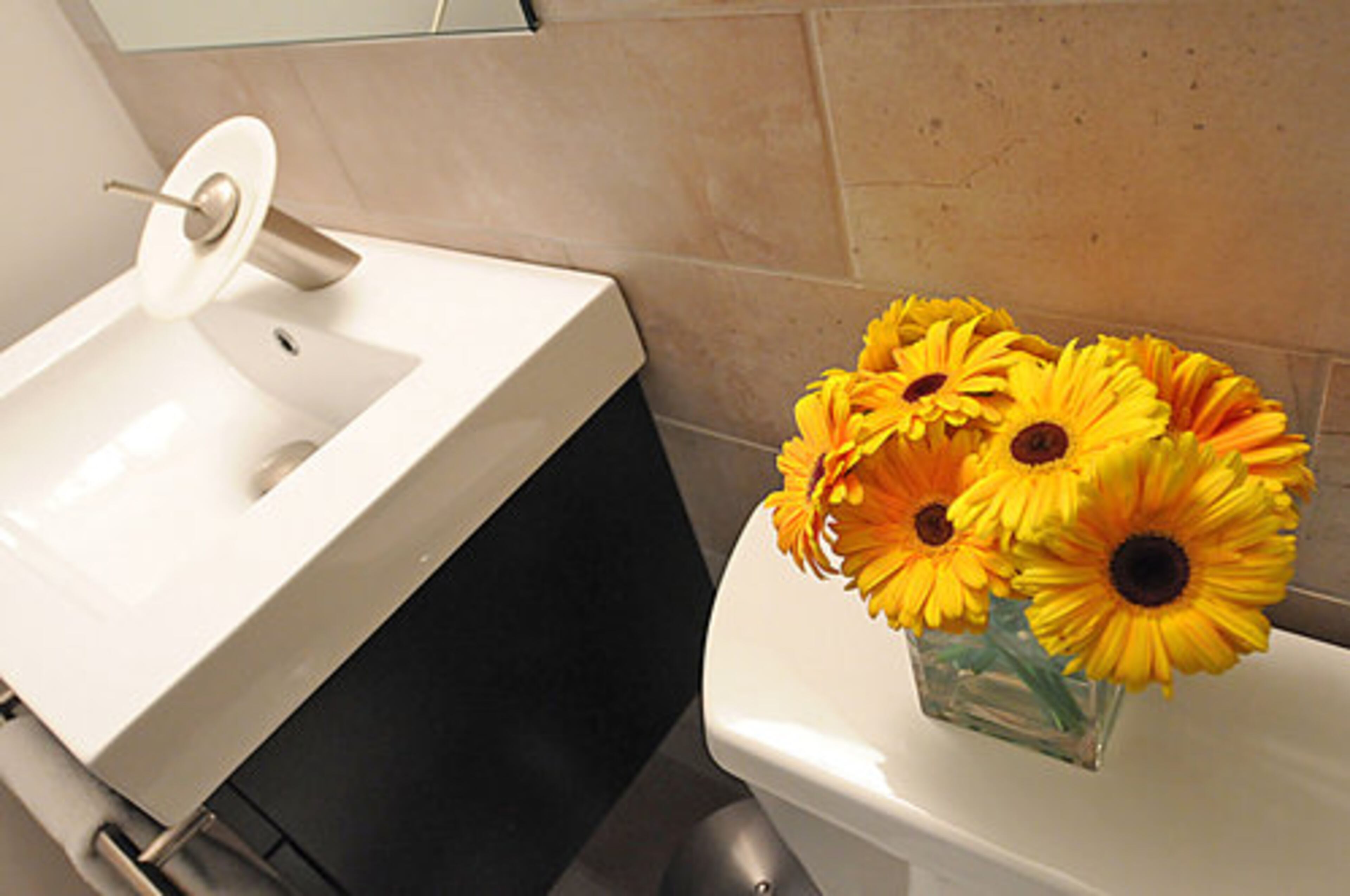Another unique, eye-catching sink design can be found in this bathroom. Here, sunflowers offer a cheerful splash of color.