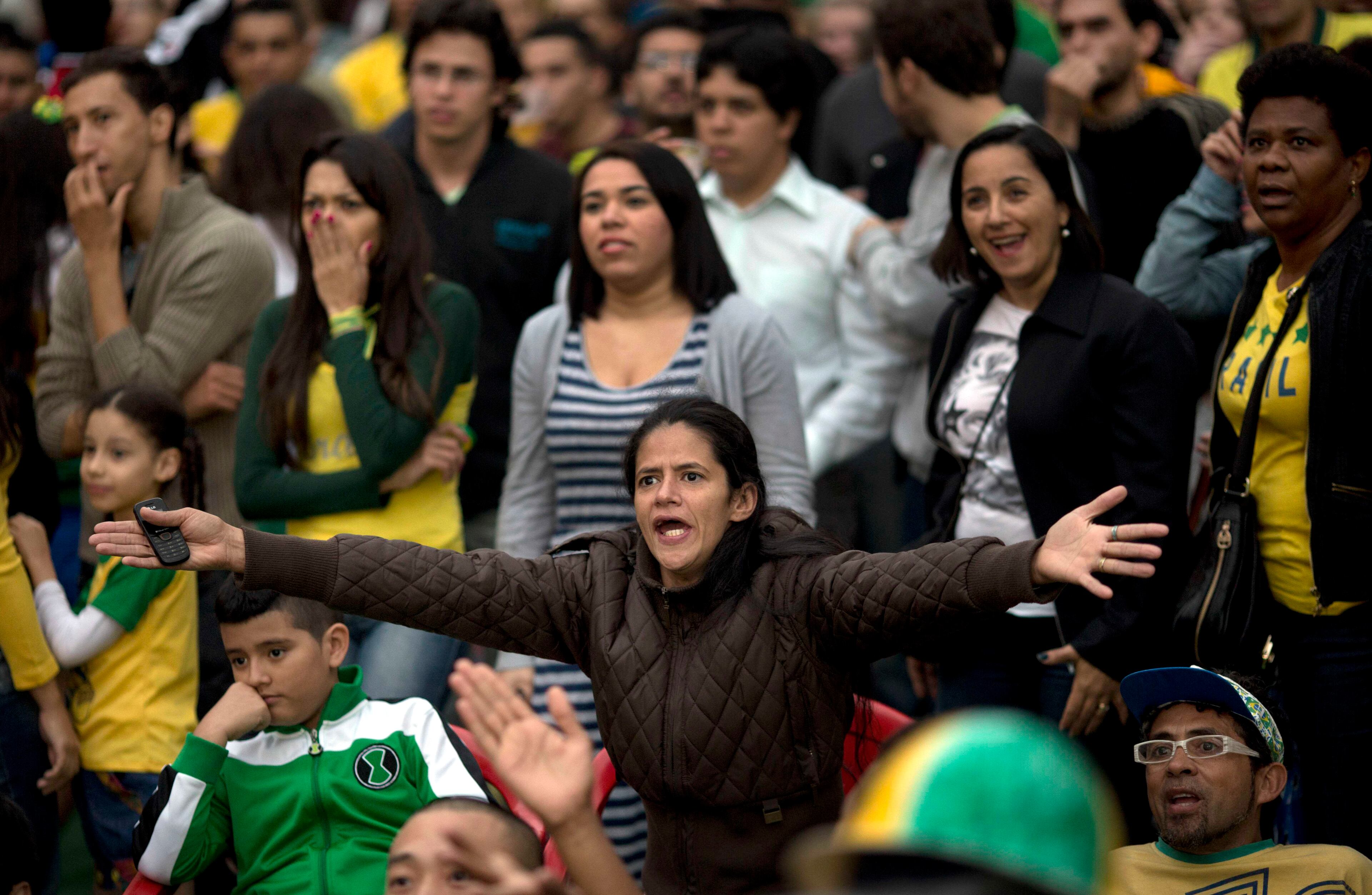 Brazil soccer fans watch their team lose to Germany at a World Cup semifinal game on TV in Sao Paulo, Brazil, Tuesday, July 8, 2014. (AP Photo/Rodrigo Abd)