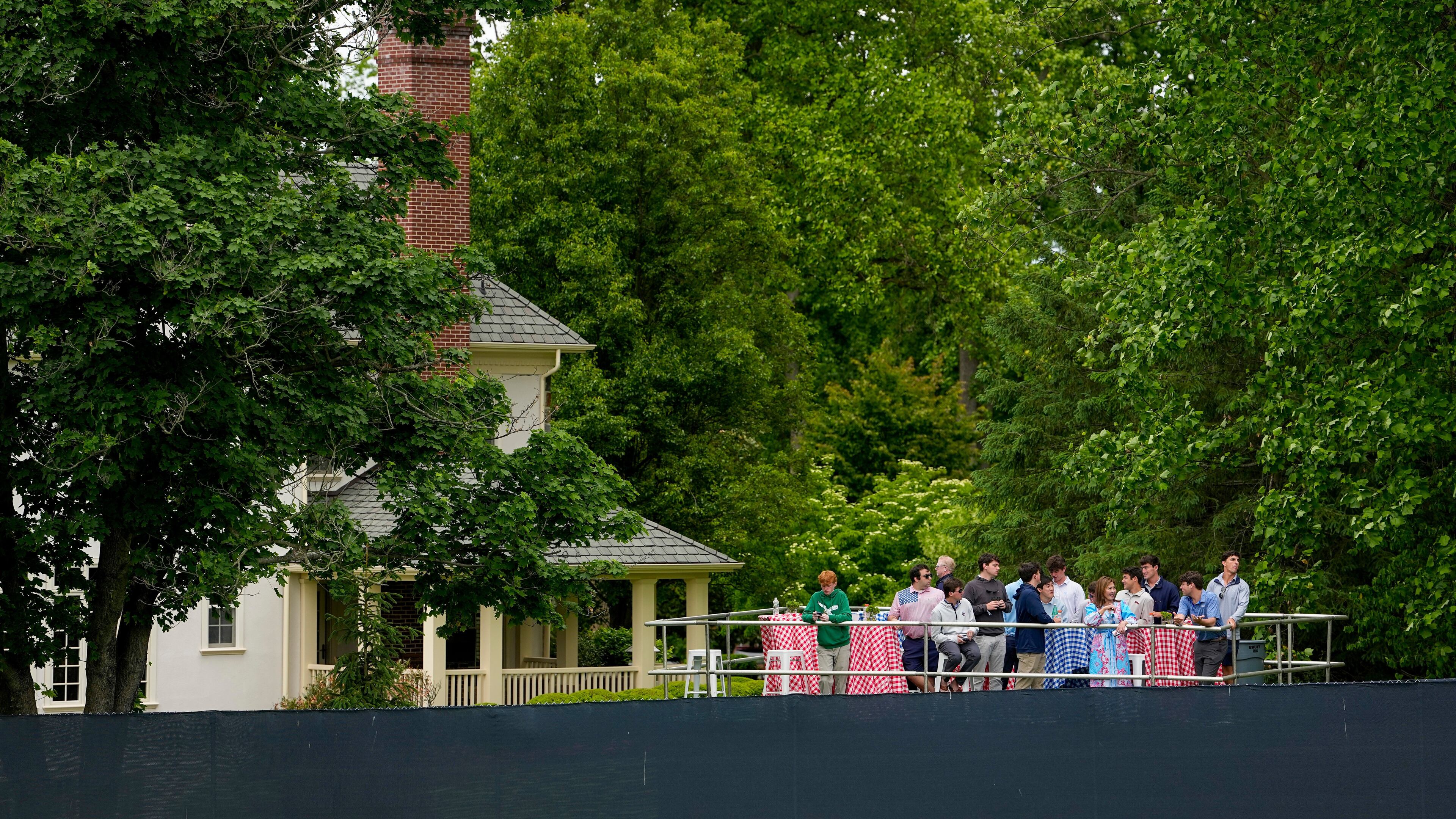 Fans watch from outside the fence line along the first fairway during the second round of the PGA Championship golf tournament at Aronimink Golf Club, Friday, May 15, 2026, in Newtown Square, PA. (AP Photo/Carolyn Kaster)