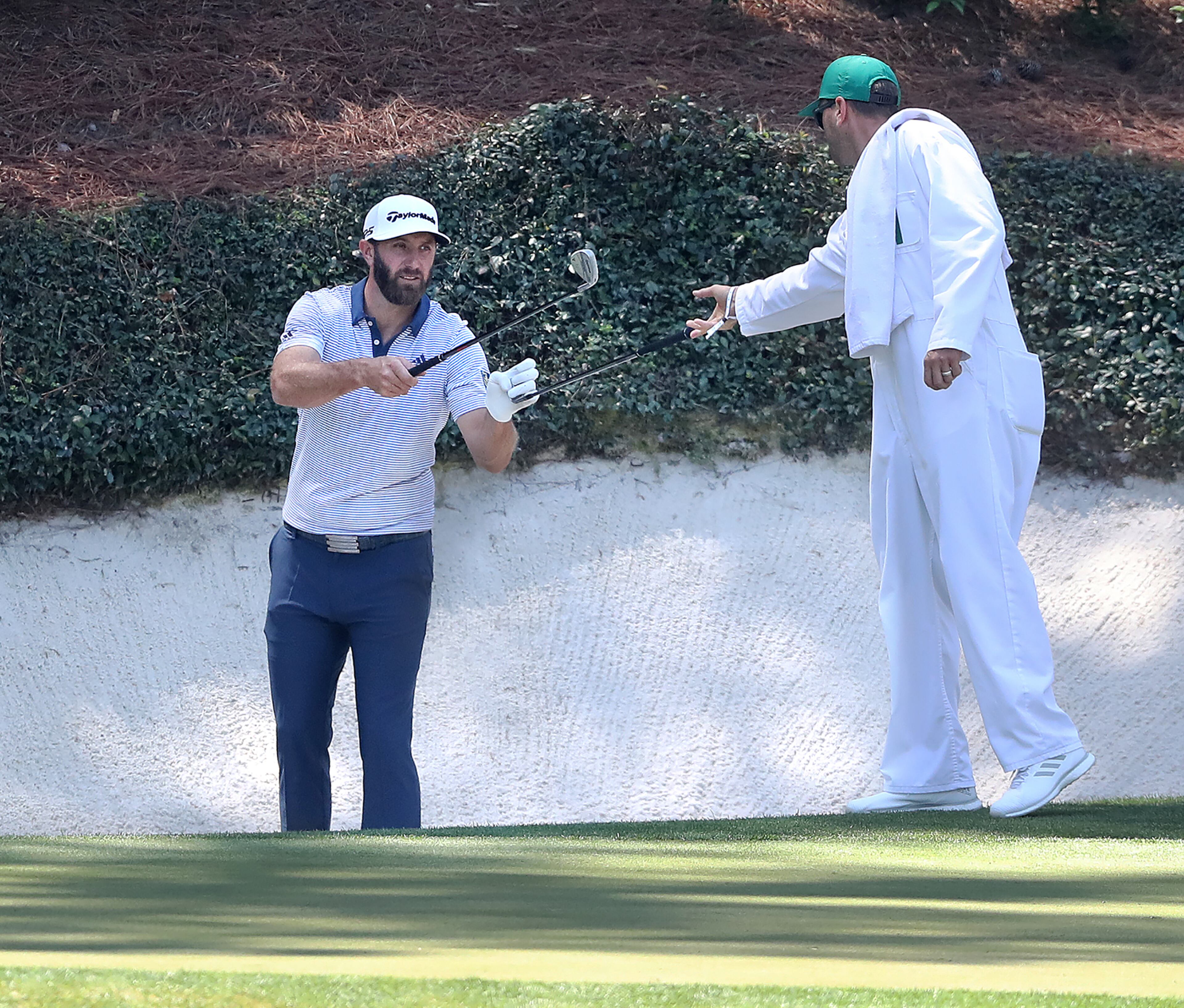040621 Augusta: Dustin Johnson changes clubs with his caddy Austin Johnson for his bunker shot at the 12th green during his practice round for the Masters at Augusta National Golf Club on Tuesday, April 6, 2021, in Augusta. “Curtis Compton / Curtis.Compton@ajc.com”