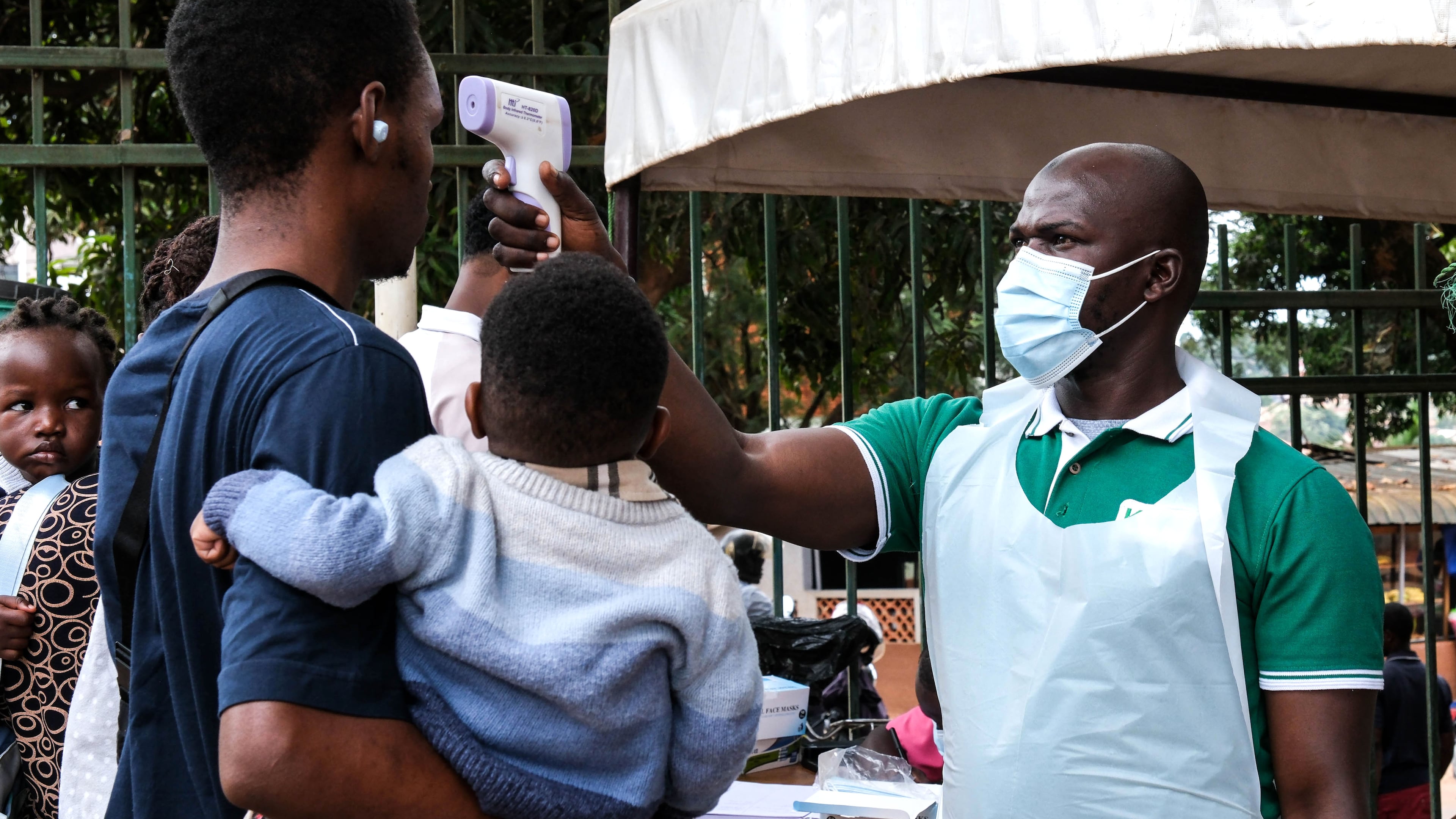 A health official uses a thermometer to screen people in front of Kibuli Muslim Hospital in Kampala, Uganda, Saturday, May 16, 2026. (AP Photo/ Hajarah Nalwadda)