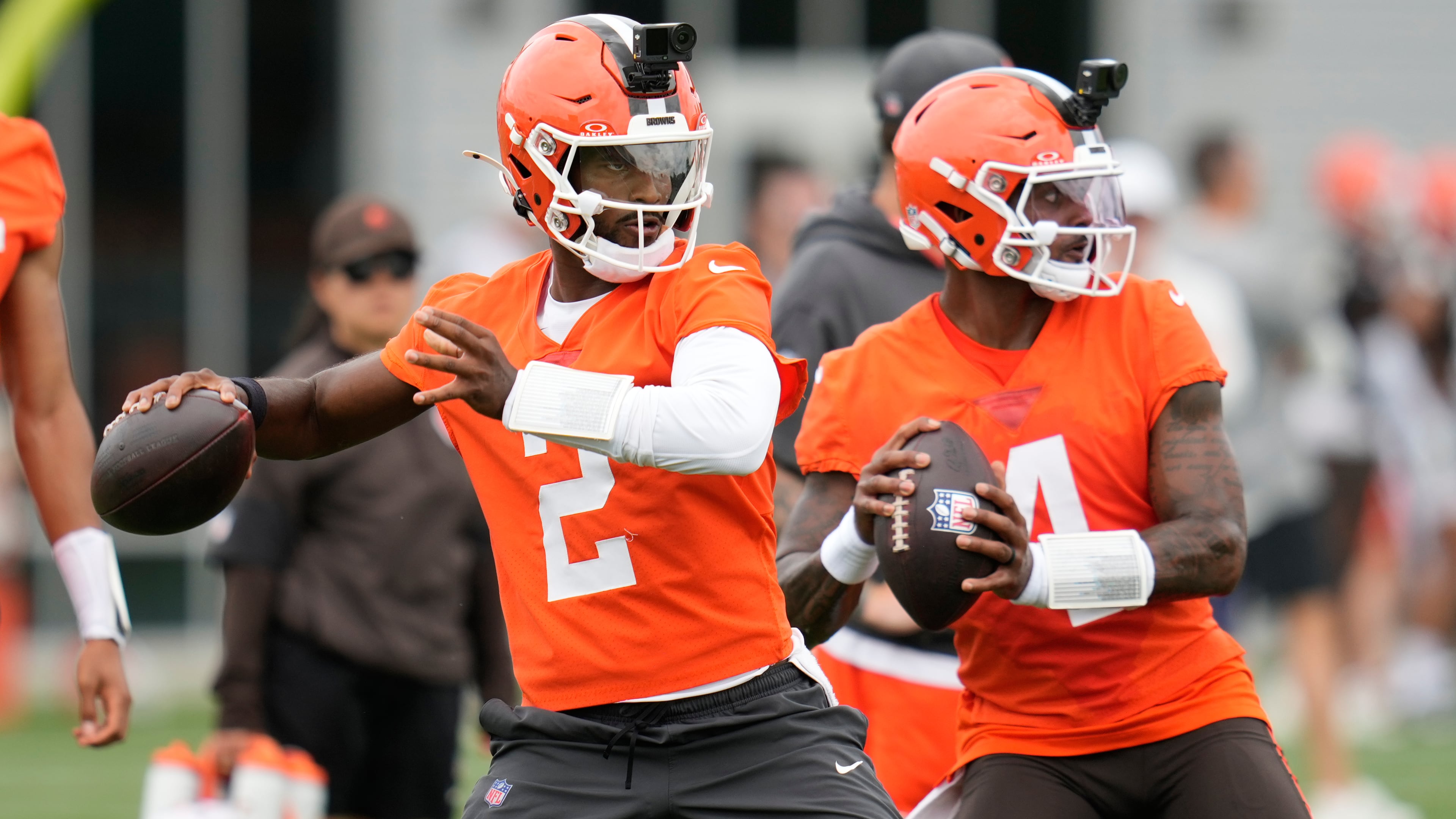 FILE - Cleveland Browns quarterbacks Shedeur Sanders, left, and Deshaun Watson, right, throw during the teams' NFL football practice, Tuesday, June 9, 2026, in Berea, Ohio. (AP Photo/Sue Ogrocki, File)