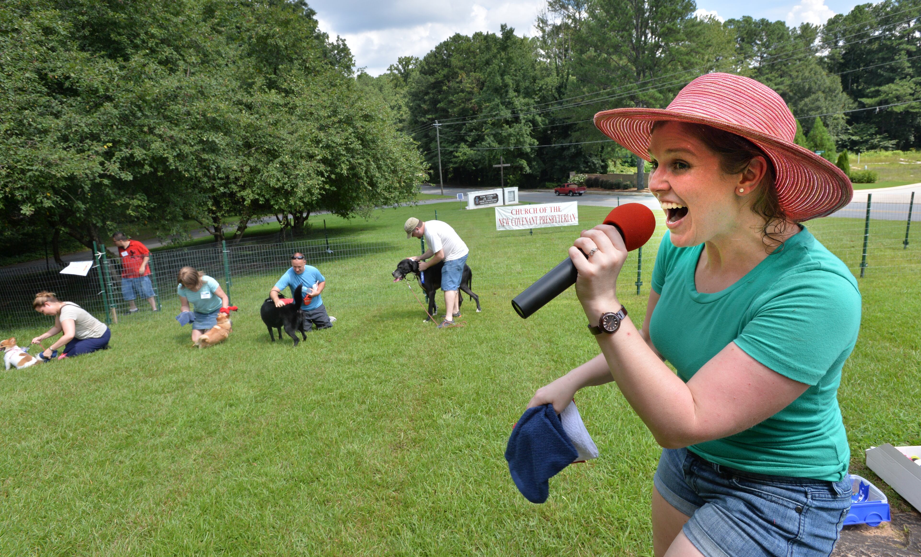 Sara Gard (right), church member and emcee, cheers during a dog competition at the Dog Dayz of Summer at Church of the New Covenant in Doraville.