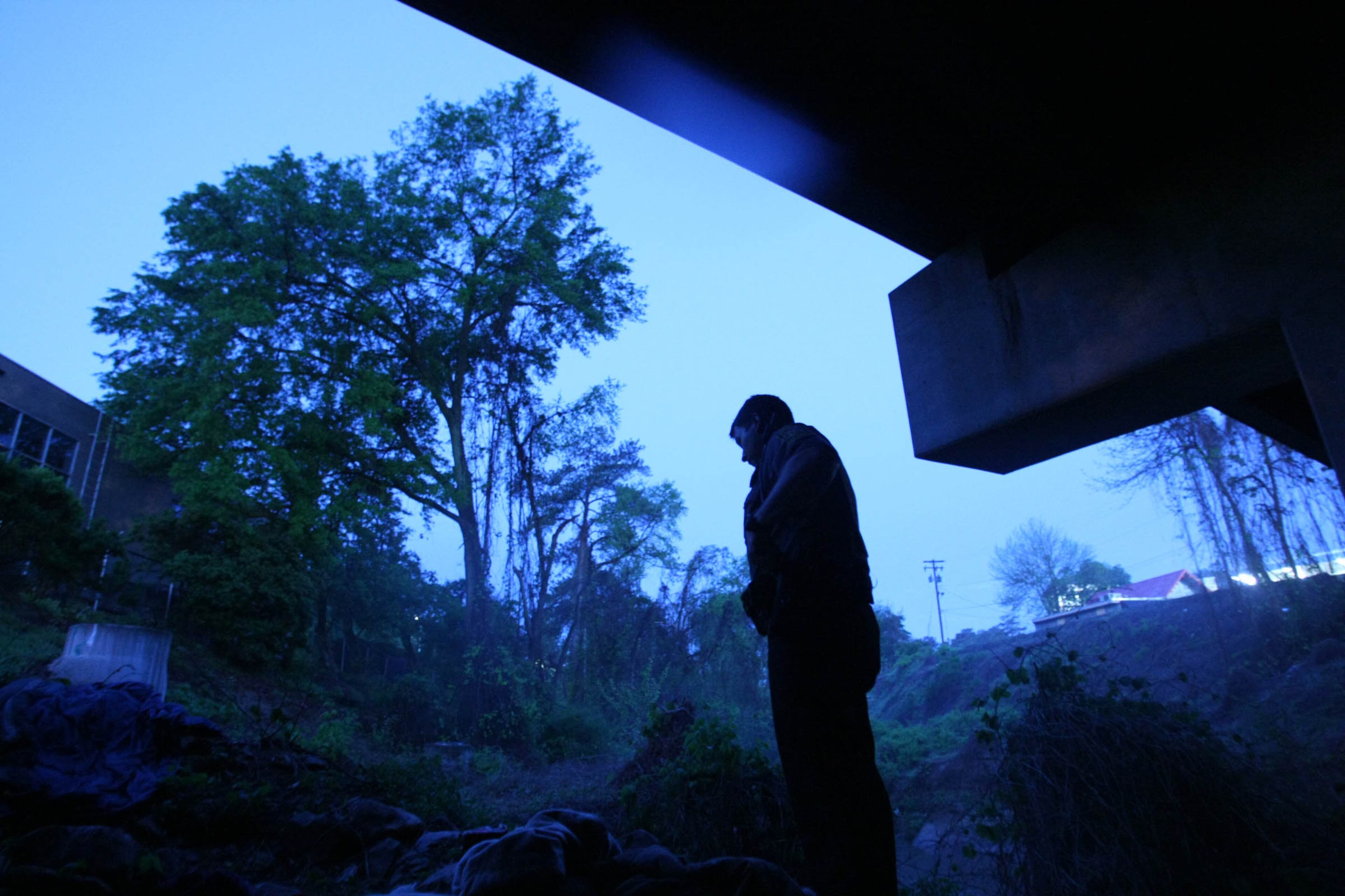 DeKalb County Police officer Jeremy Turner, pictured here in 2009 beneath a North Druid Hills overpass at North Peachtree Creek, often ventures to these hidden spots where homeless people gather so he can offer them aid. JASON GETZ