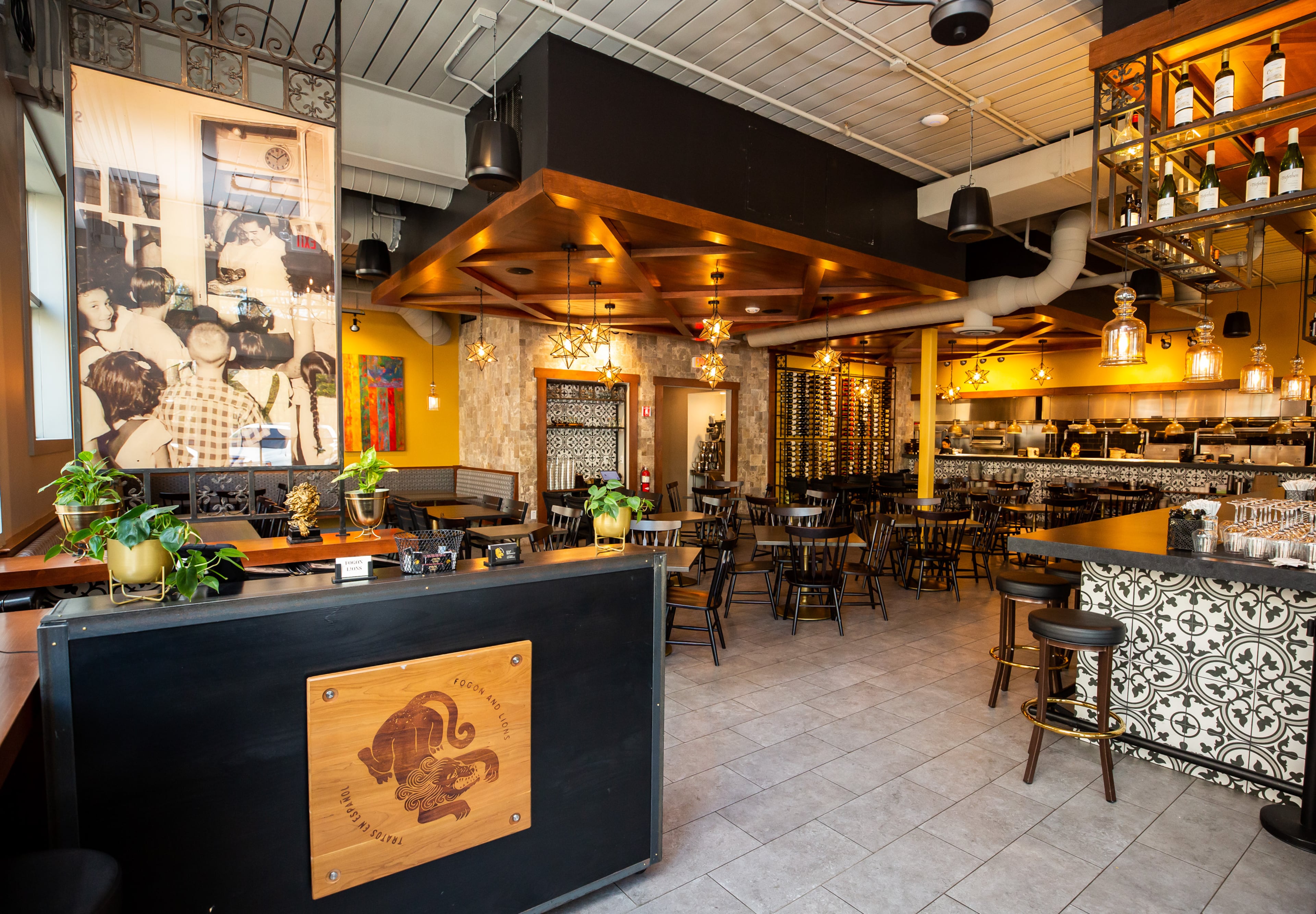 A reprint of Julio Delgado's butcher grandfather hangs above the host stand at Fogón and Lions. His grandfather's shop in Ponce, Puerto Rico, was an integral part of family life in in the area. (Ryan Fleisher for the AJC)