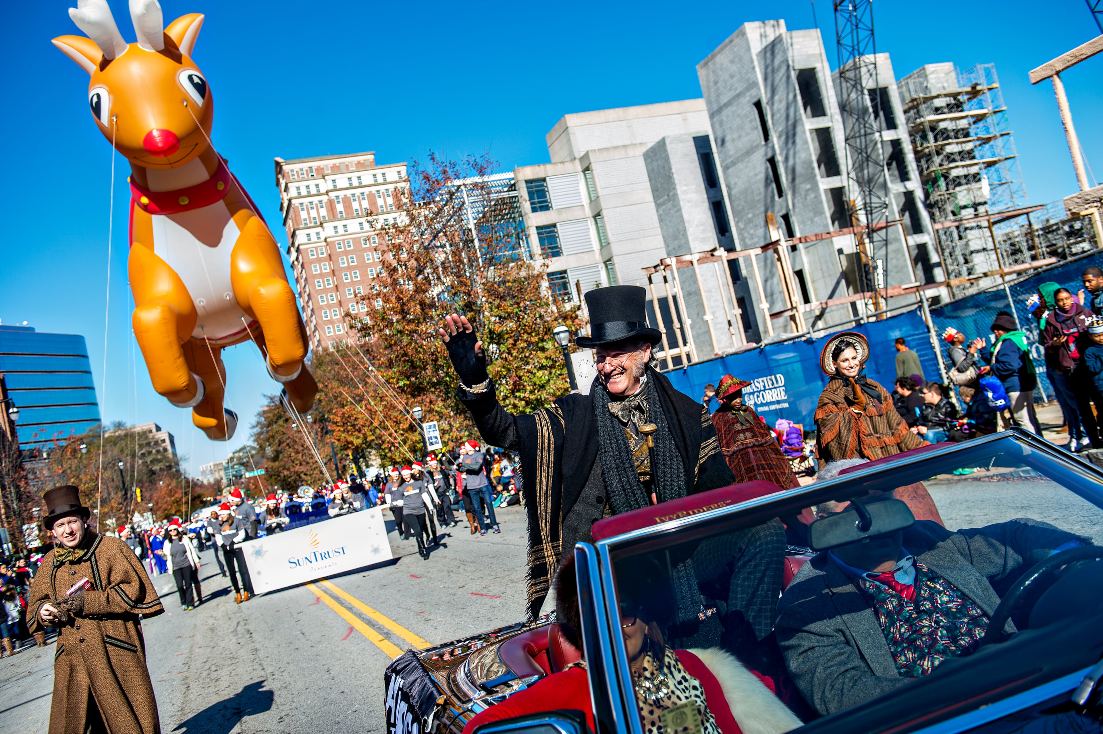 December 5, 2015 Atlanta - David DeVries (center), who plays Scrooge for the Alliance Theatre, waves to the crowd during the 2015 Children's Christmas Parade in Atlanta on Saturday, December 5, 2015. Thousands gathered along Peachtree St. to watch the parade pass with marching bands, balloons, performances and more. JONATHAN PHILLIPS / SPECIAL