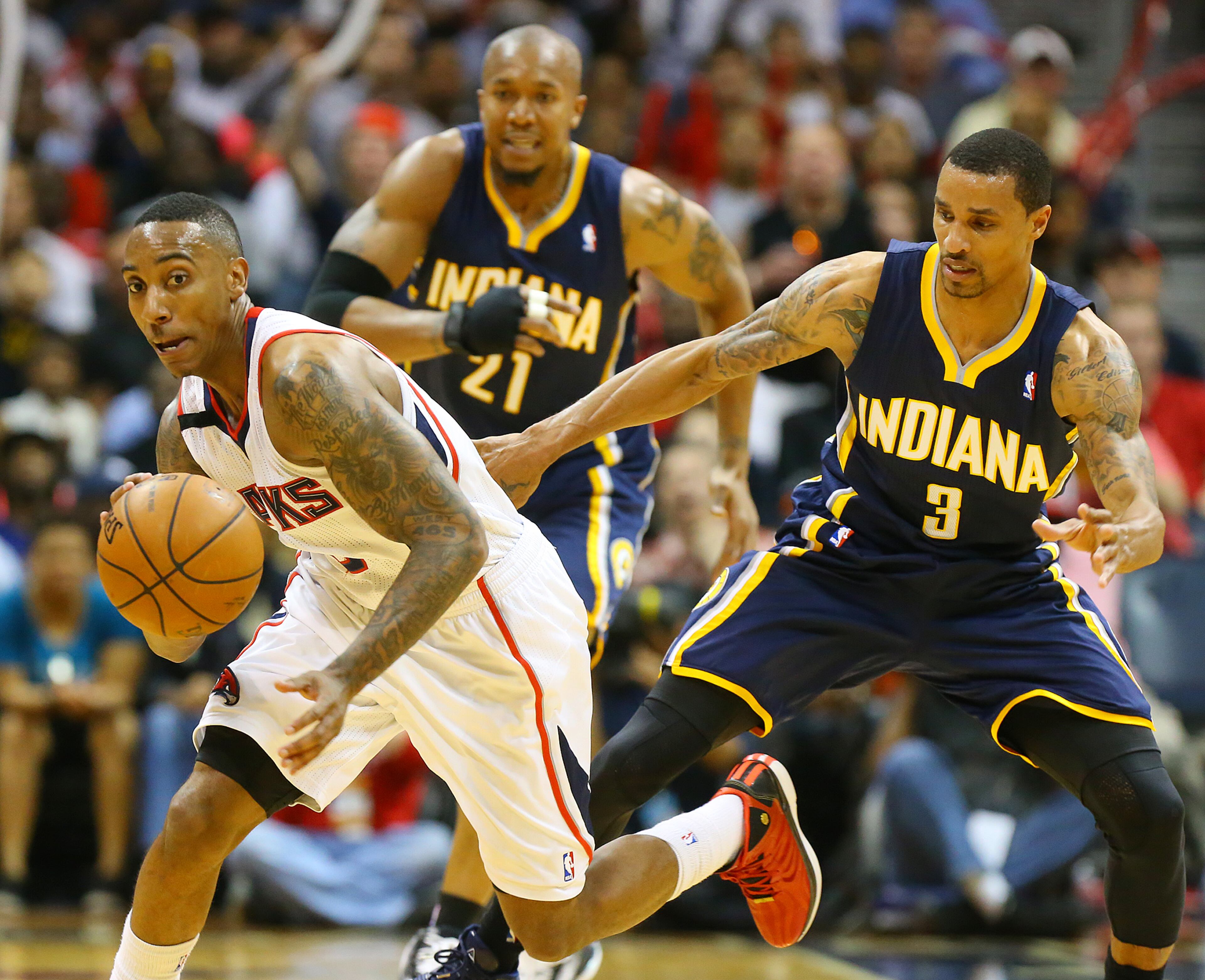 Jeff Teague steals the ball from Pacers George Hill with David West looking on, beating the Pacers 98-85 for a 2 games to 1 lead during the second half of their NBA playoff game on Thursday, April 24, 2014, in Atlanta. CURTIS COMPTON / CCOMPTON@AJC.COM