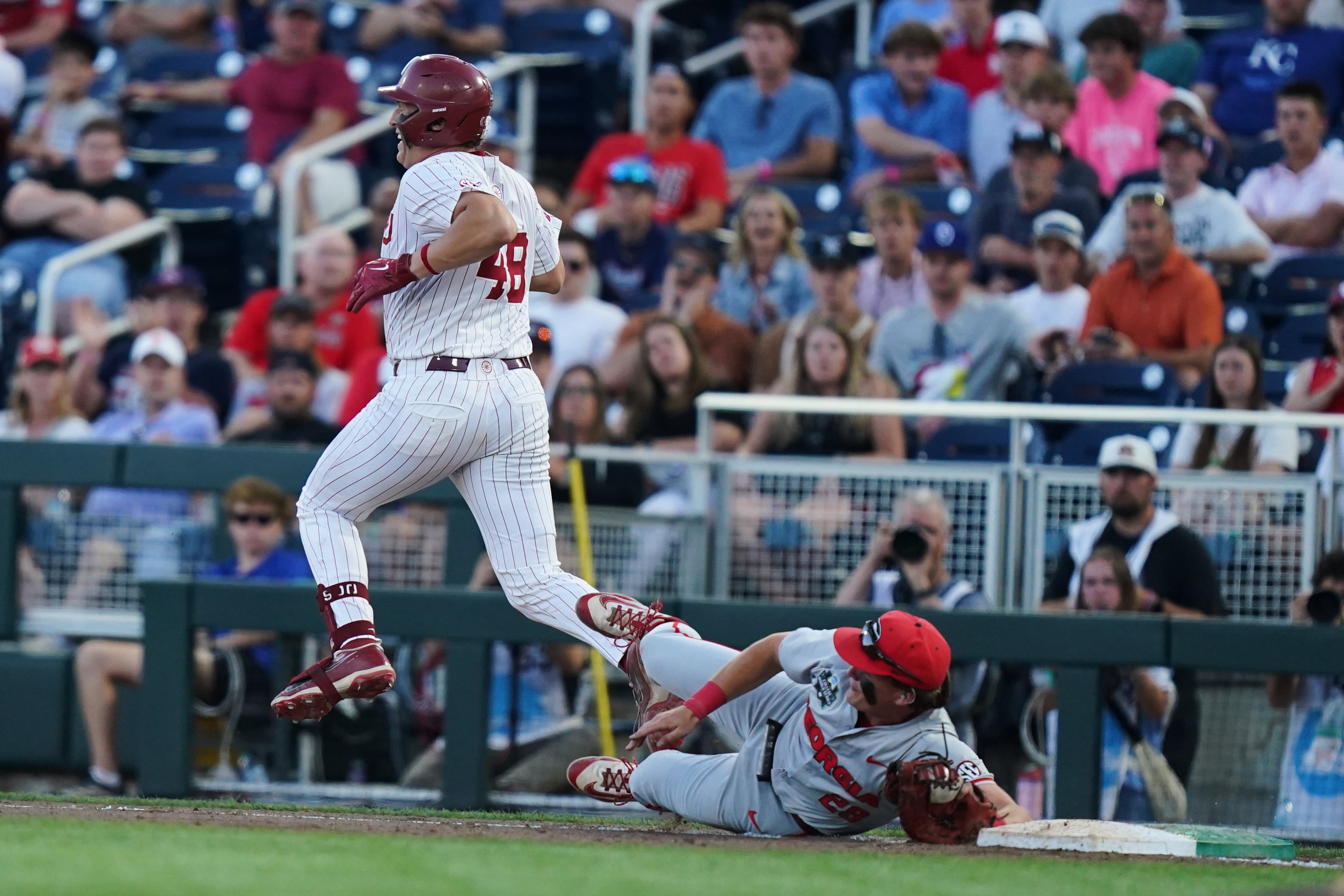 Georgia catcher Brennan Hudson (right) makes a diving play but just misses getting Oklahoma catcher Deiten Lachance out at first during their College World Series game on Monday, June 15, 2026, in Omaha, Neb. (Vera Nieuwenhuis/AP)