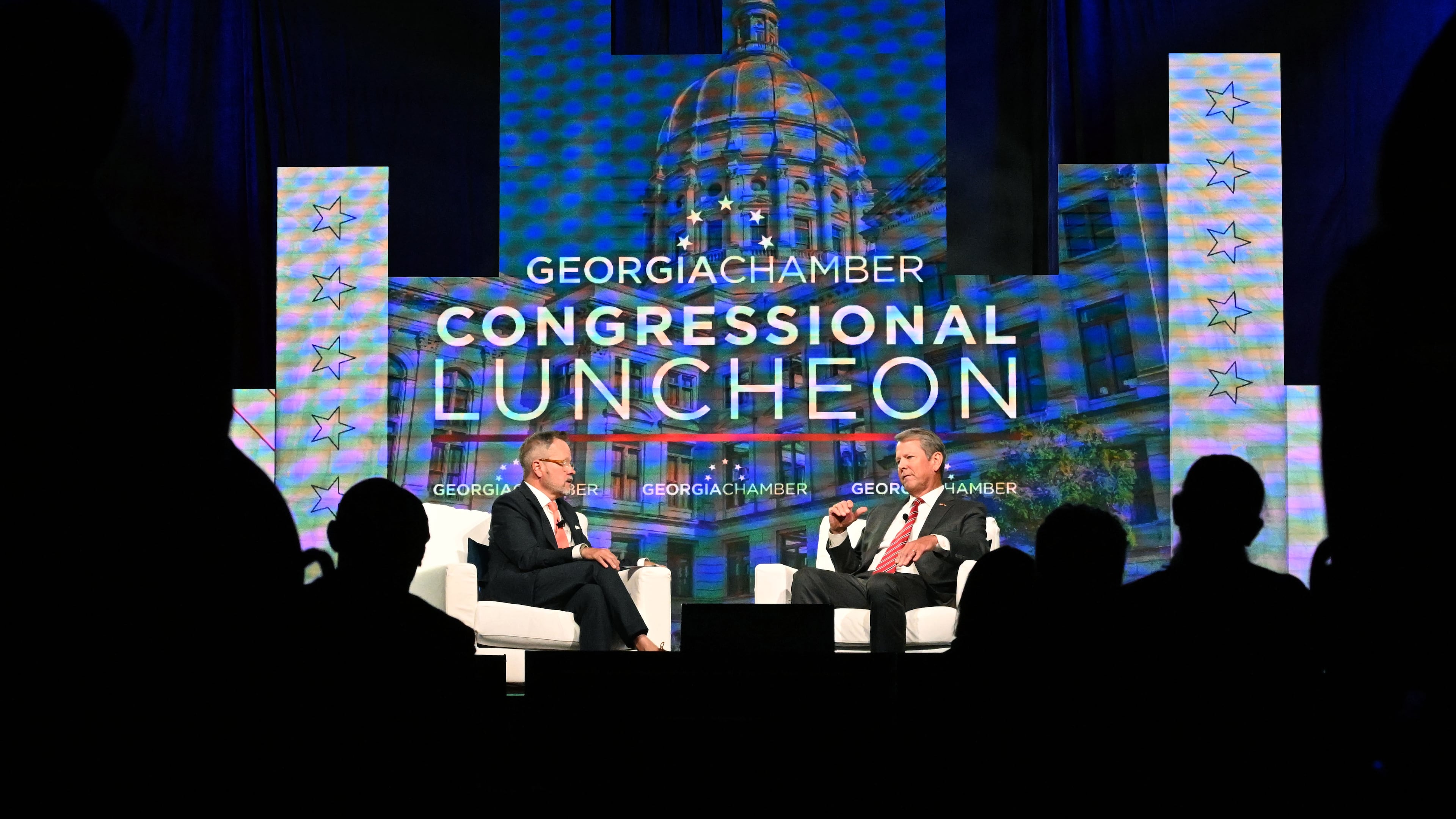 Gov. Brian Kemp (right) speaks during the Georgia Chamber of Commerce's annual congressional luncheon in Athens on Wednesday. (Hyosub Shin/AJC)