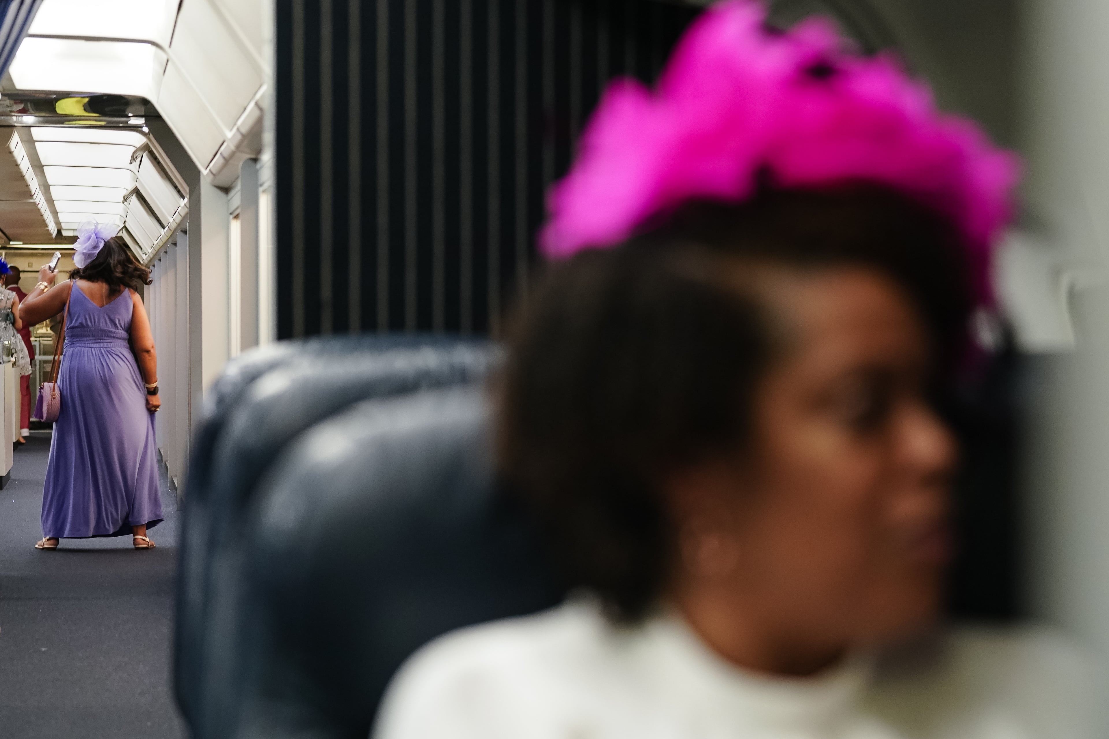 A woman dances inside an airplane at the Alpha Derby, a Kentucky-Derby-themed event that raises thousands for scholarships, at the Delta Flight Museum on Saturday, May 4, 2024, in Atlanta. (Elijah Nouvelage for The Atlanta Journal-Constitution)