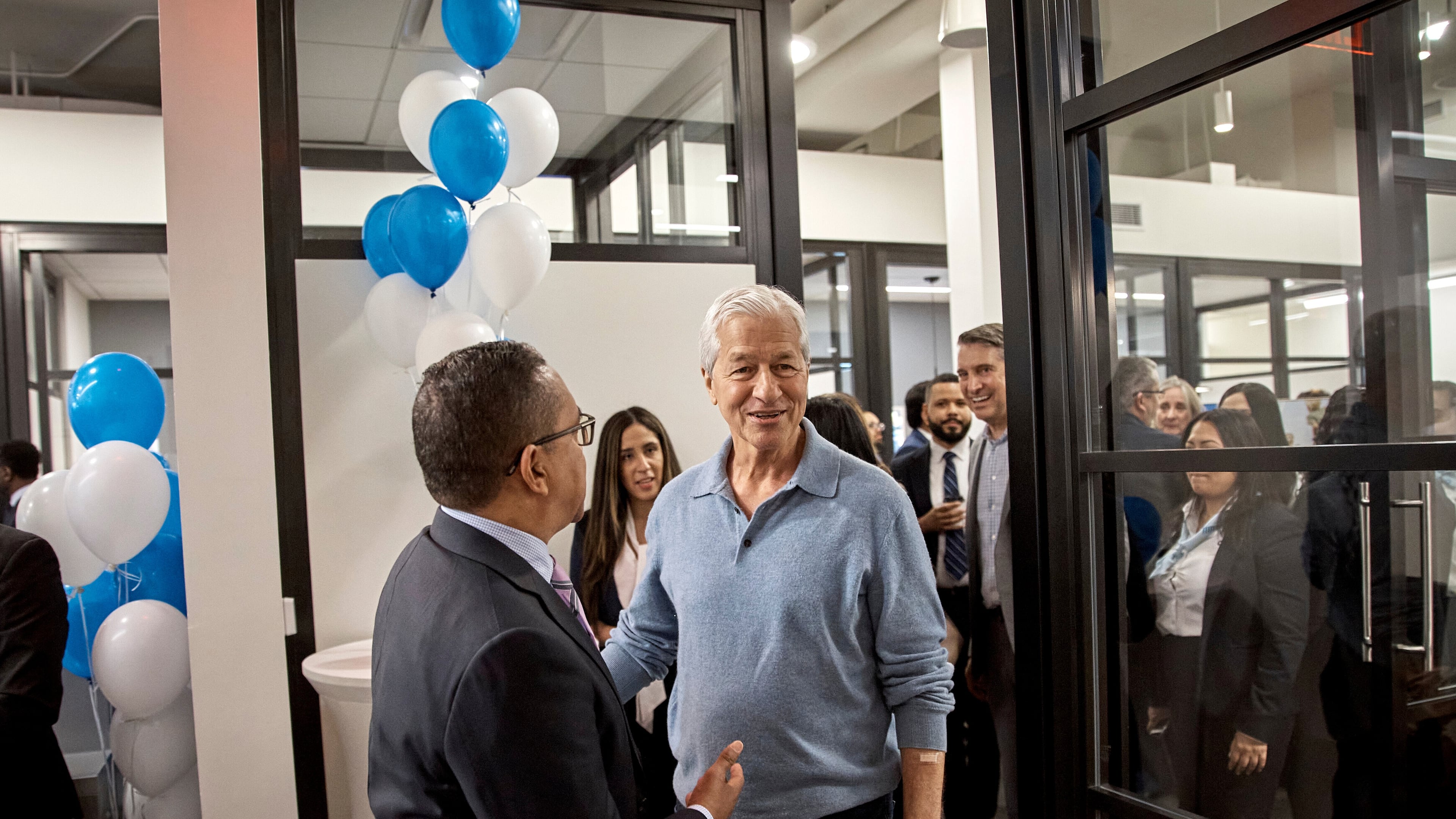 FILE - Jamie Dimon, CEO and chairman of JPMorgan Chase, center right, talks with an attendee during the community branch opening in the Bronx borough of New York, April 26, 2024. (AP Photo/Andres Kudacki, File)