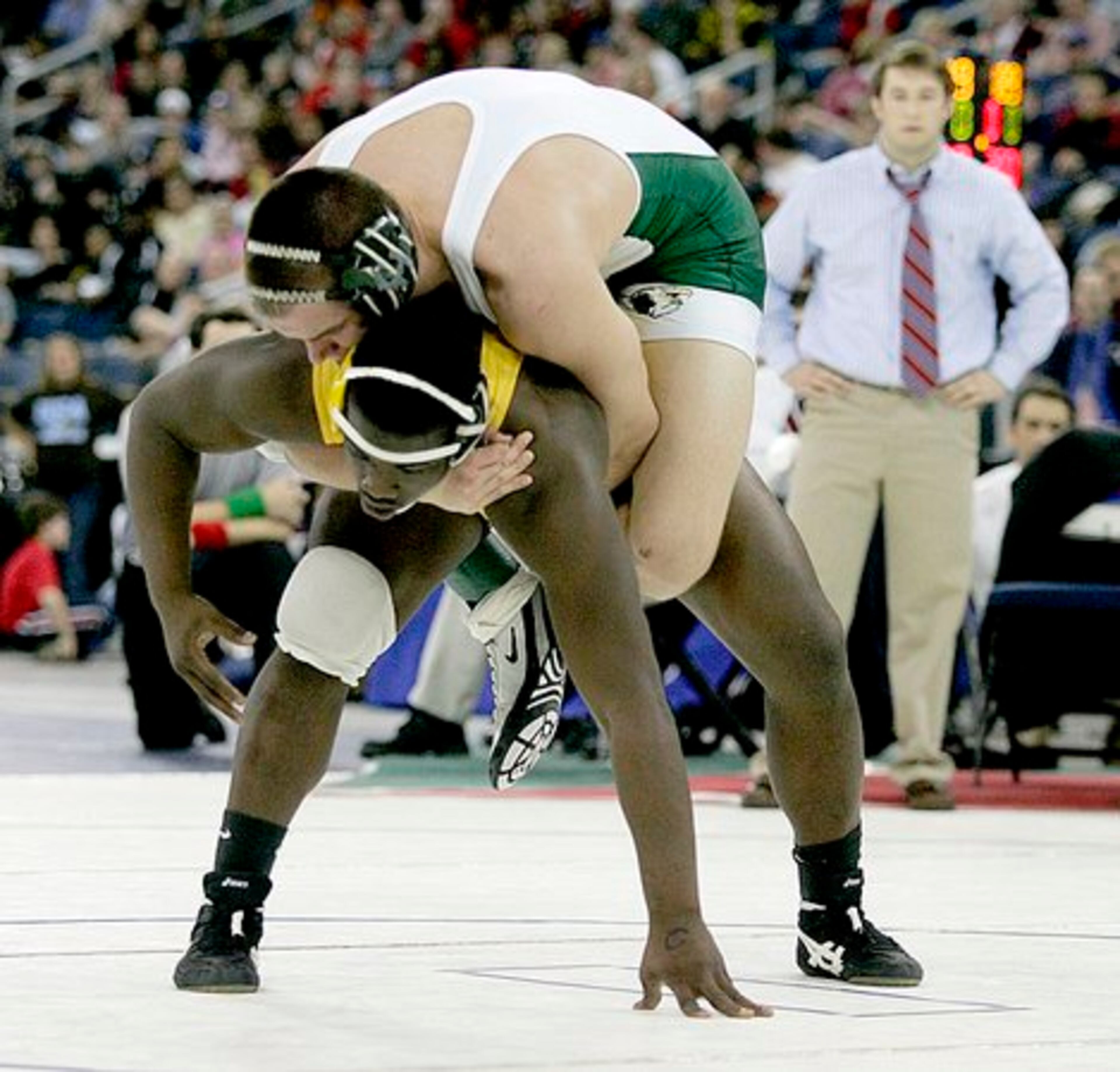 Collins Hill's Christopher Collins (top) hangs on to Valdosta's Allen Scruggs during the Class AAAAA 215-pound finals.