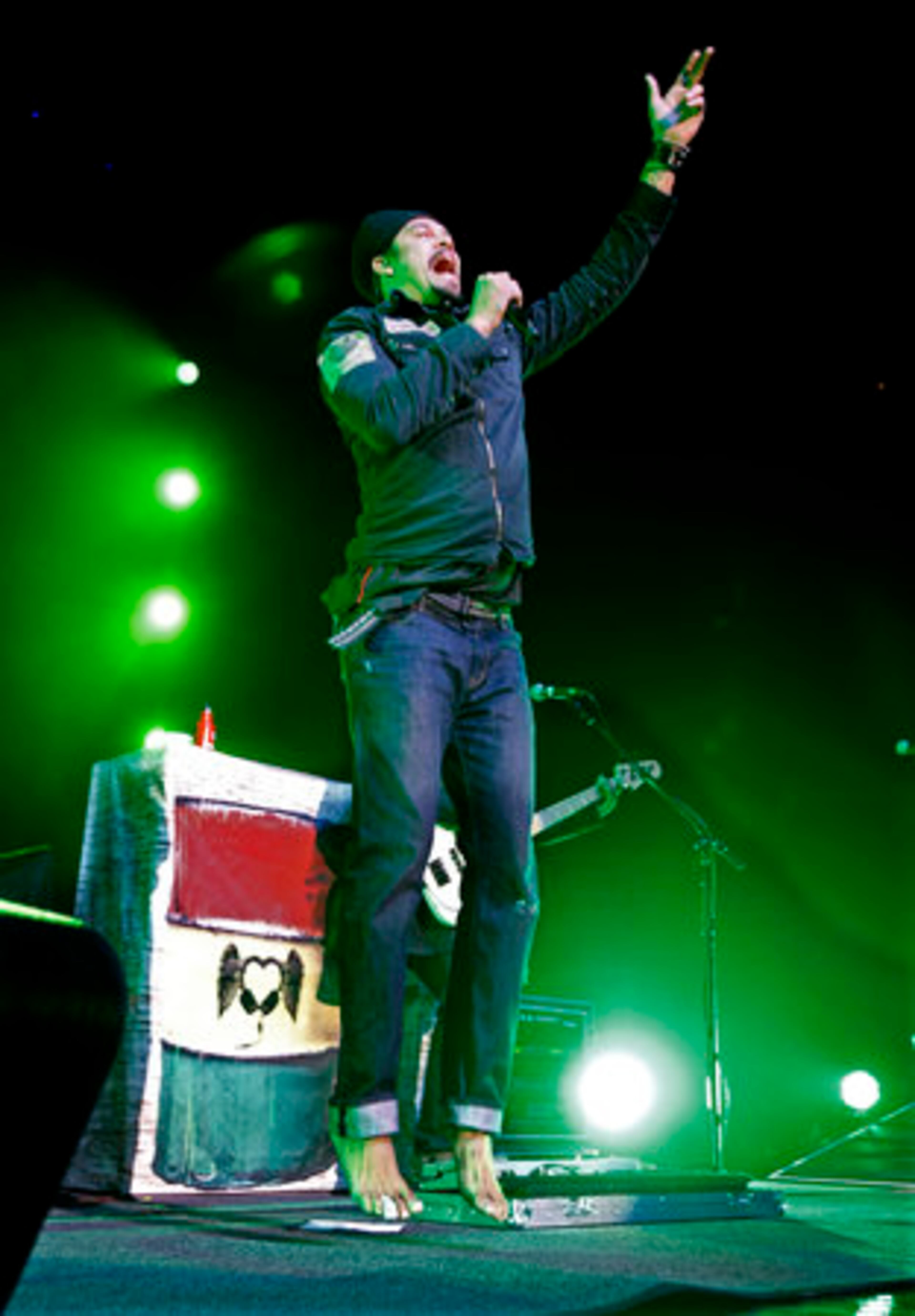Michael Franti performs barefoot leaping into the air.