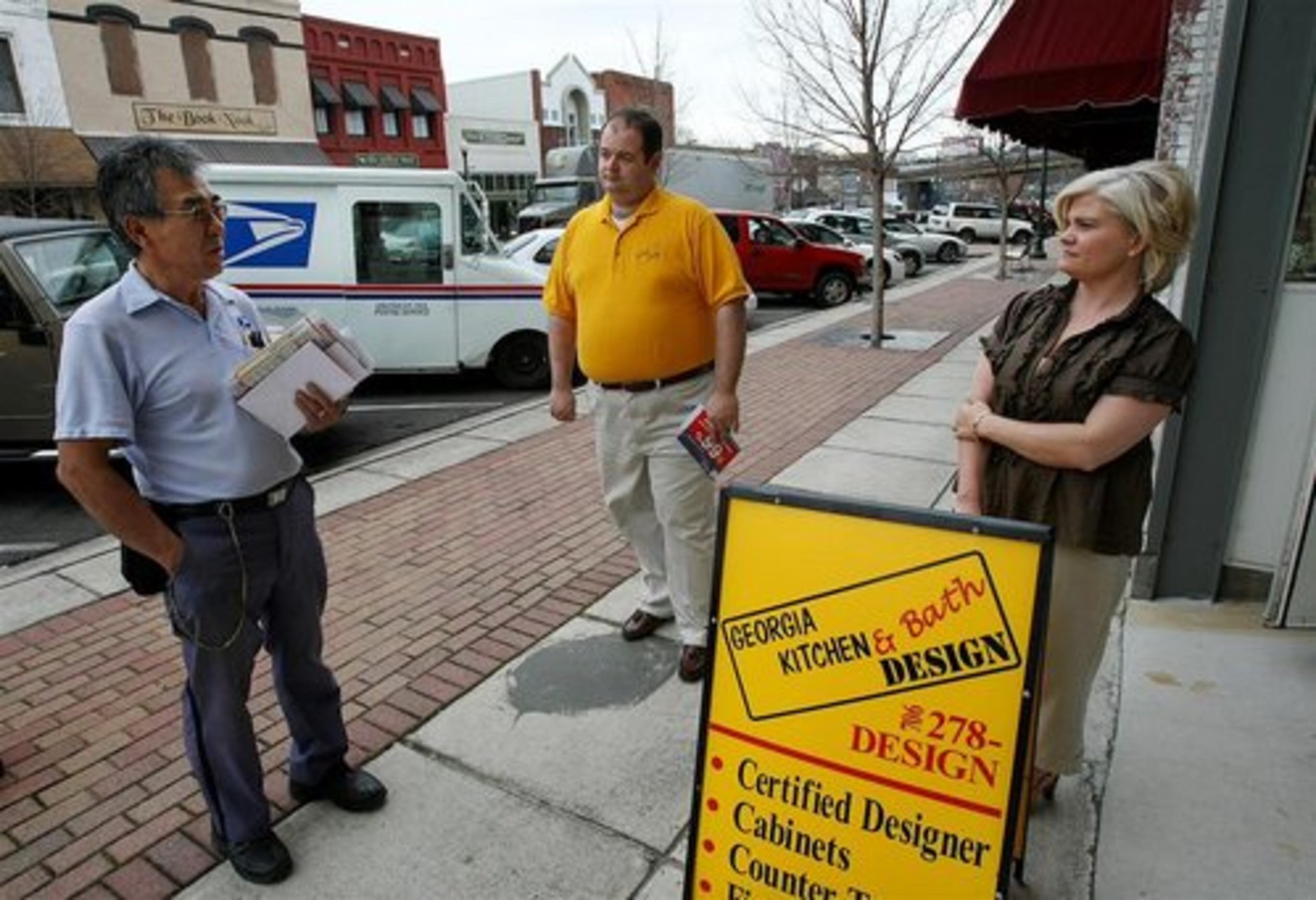 "Even the mail is slow" says postal carrier Tom Moore as he pauses to discuss the economy with Kyle Dinsmore (center), owner of Georgia Kitchen & Bath Design, and his interior designer Kimberly Steed on North Hamilton Street in the historic district of Dalton.