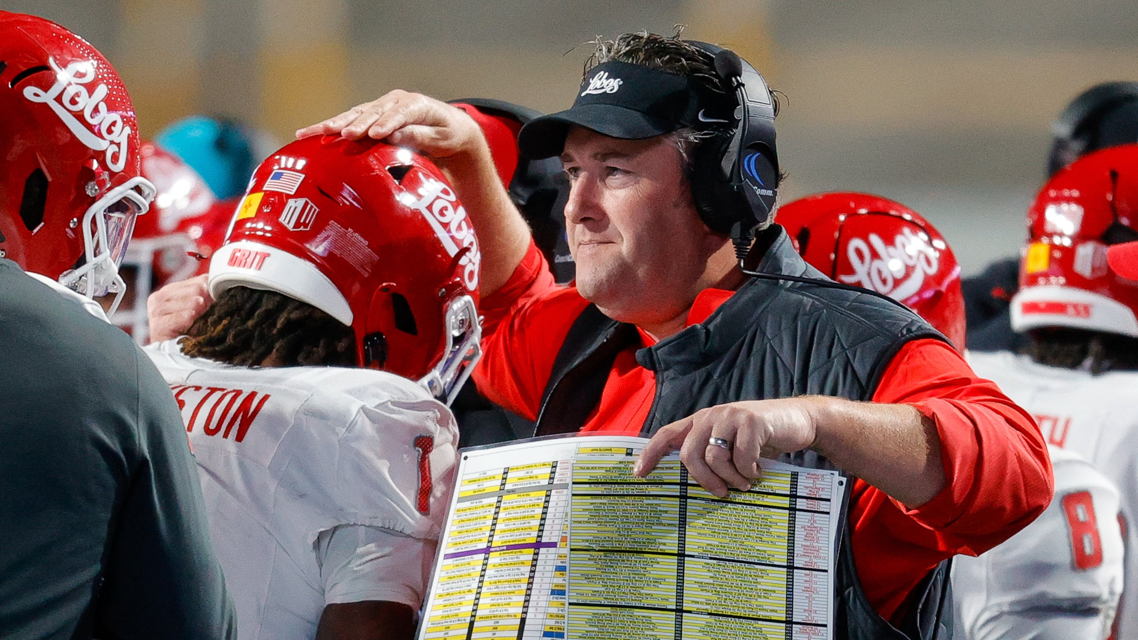 FILE - New Mexico head coach Jason Eck taps running back Damon Bankston (1) on the head after his long kickoff return for a touchdown in the first half of an NCAA college football game, Oct. 11, 2025, in Boise, Idaho. (AP Photo/Steve Conner, File)